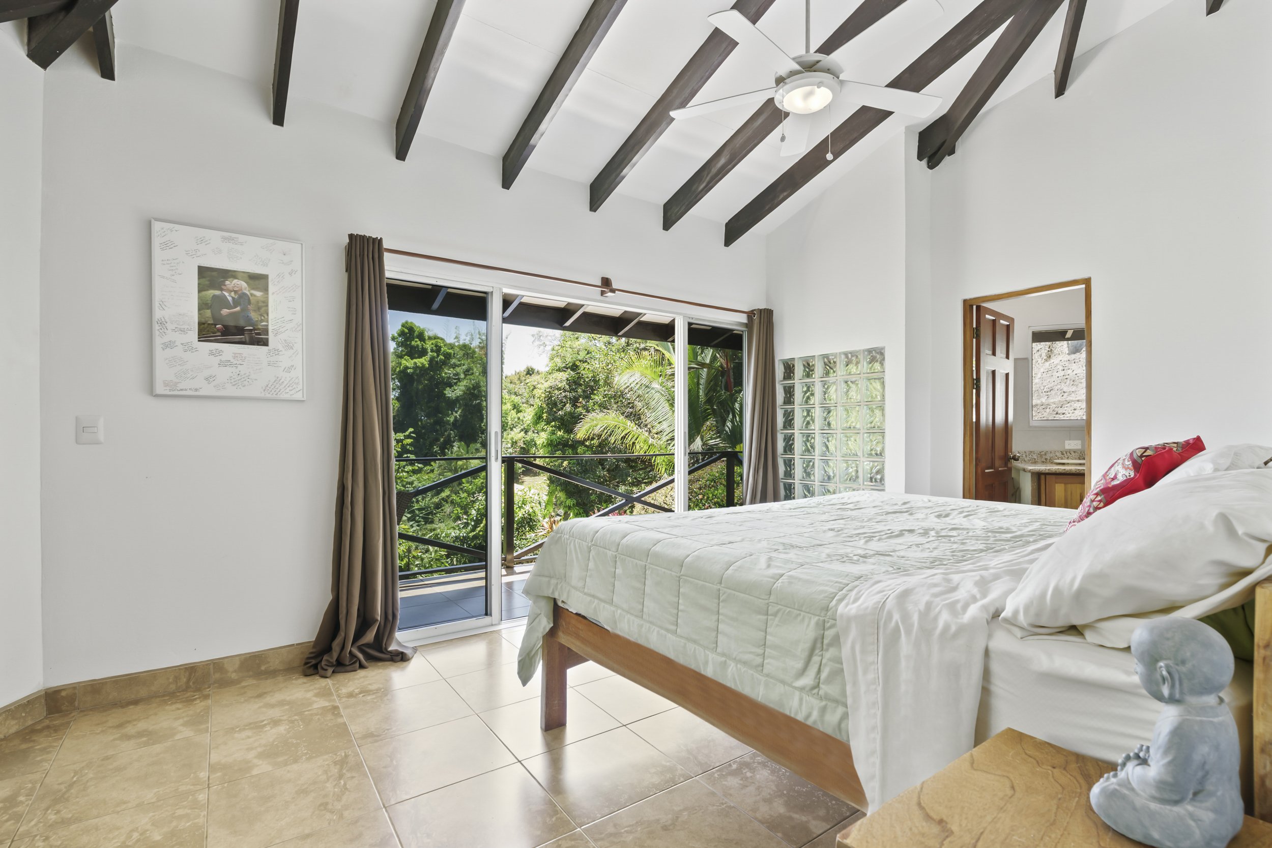 Second primary suite emphasizing openness and natural light. Note the glass blocks bordering the shower. Ceiling fixtures with fans are in all living areas.