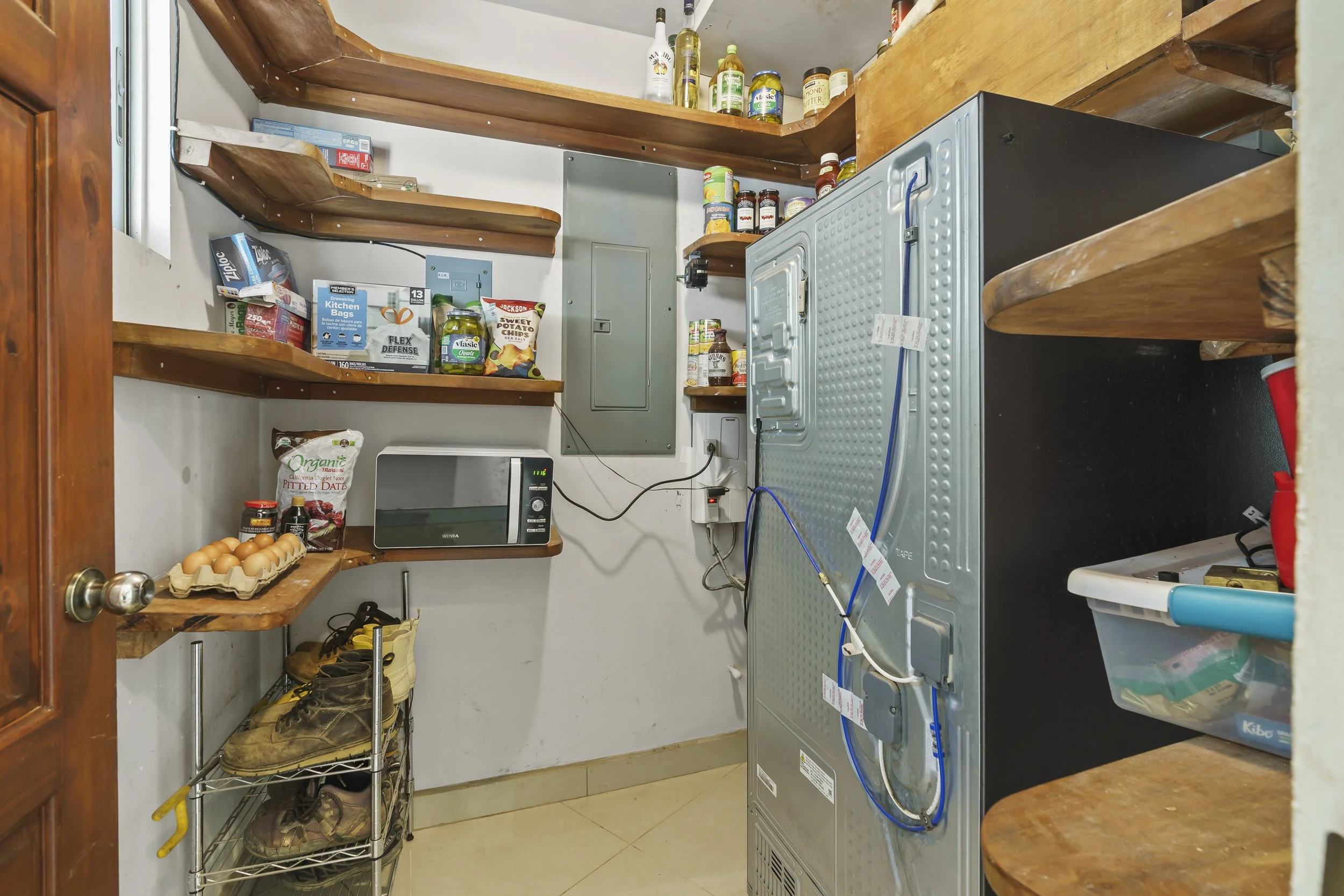 Ample kitchen pantry offering storage space for everyday living conveniently located on the hall from the carport on your way to the kitchen.