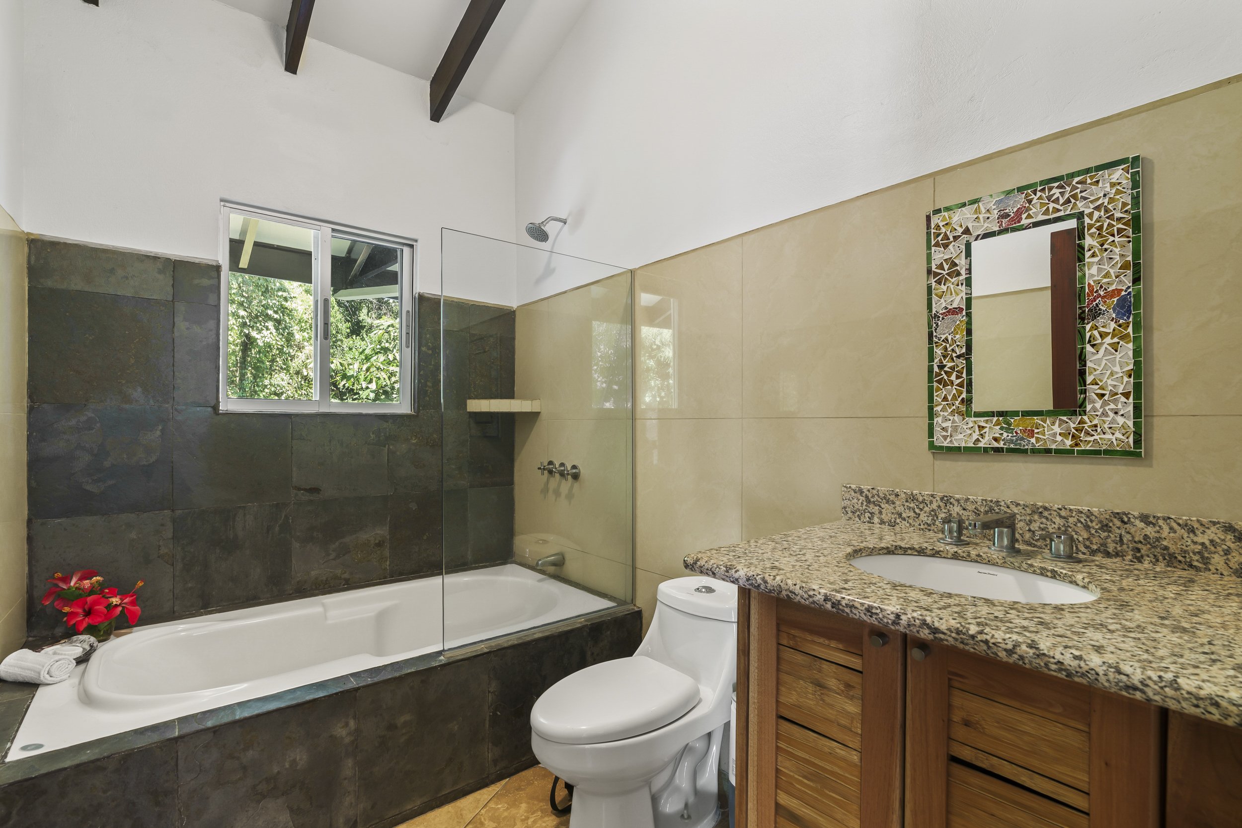 A luxurious bathtub in the primary suite — a rare feature in tropical Costa Rica homes. Artistic mosaic mirrors are throught the home.
