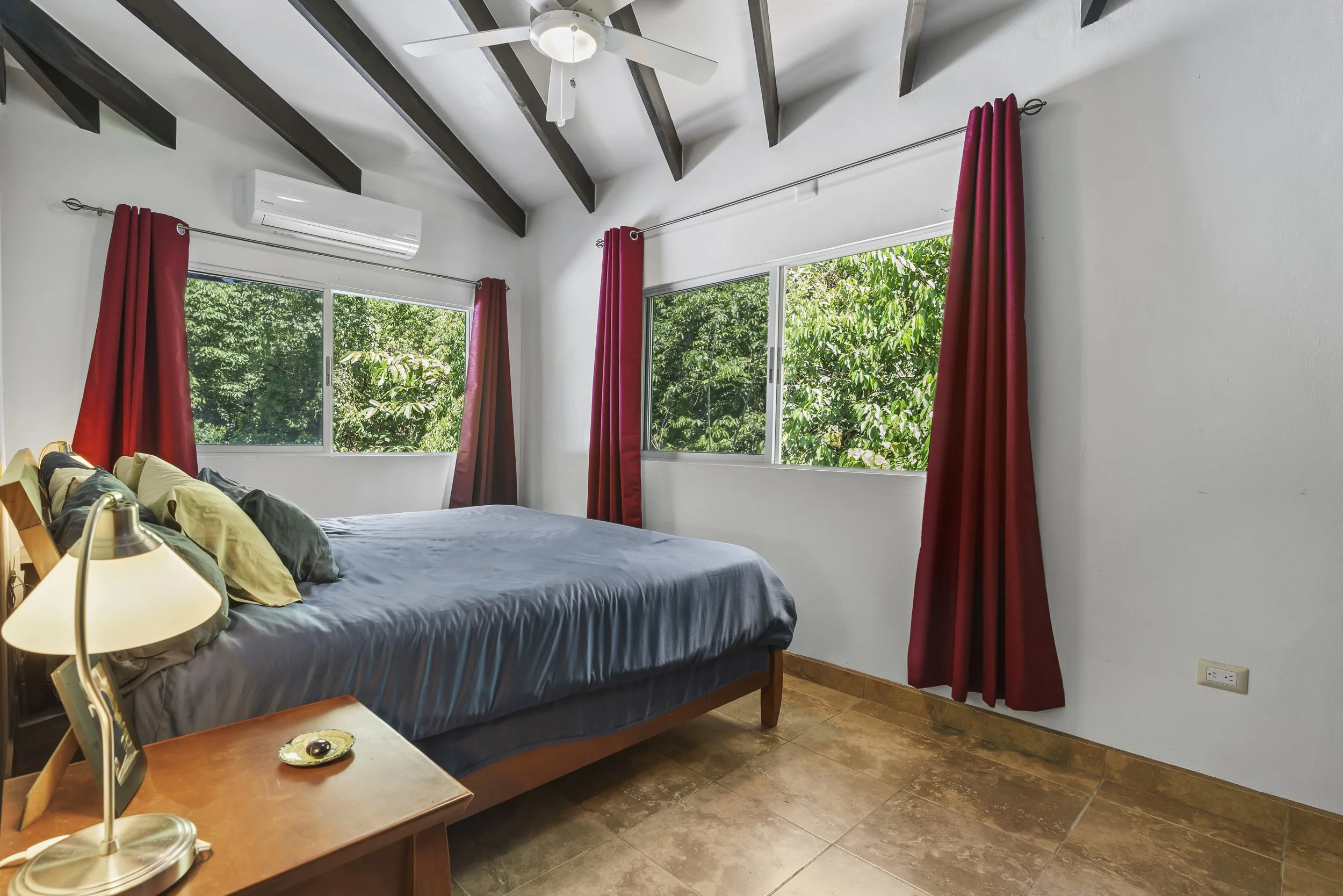 Guest bedroom offering natural light and peaceful jungle surroundings. This is the second room that has an air conditioner.