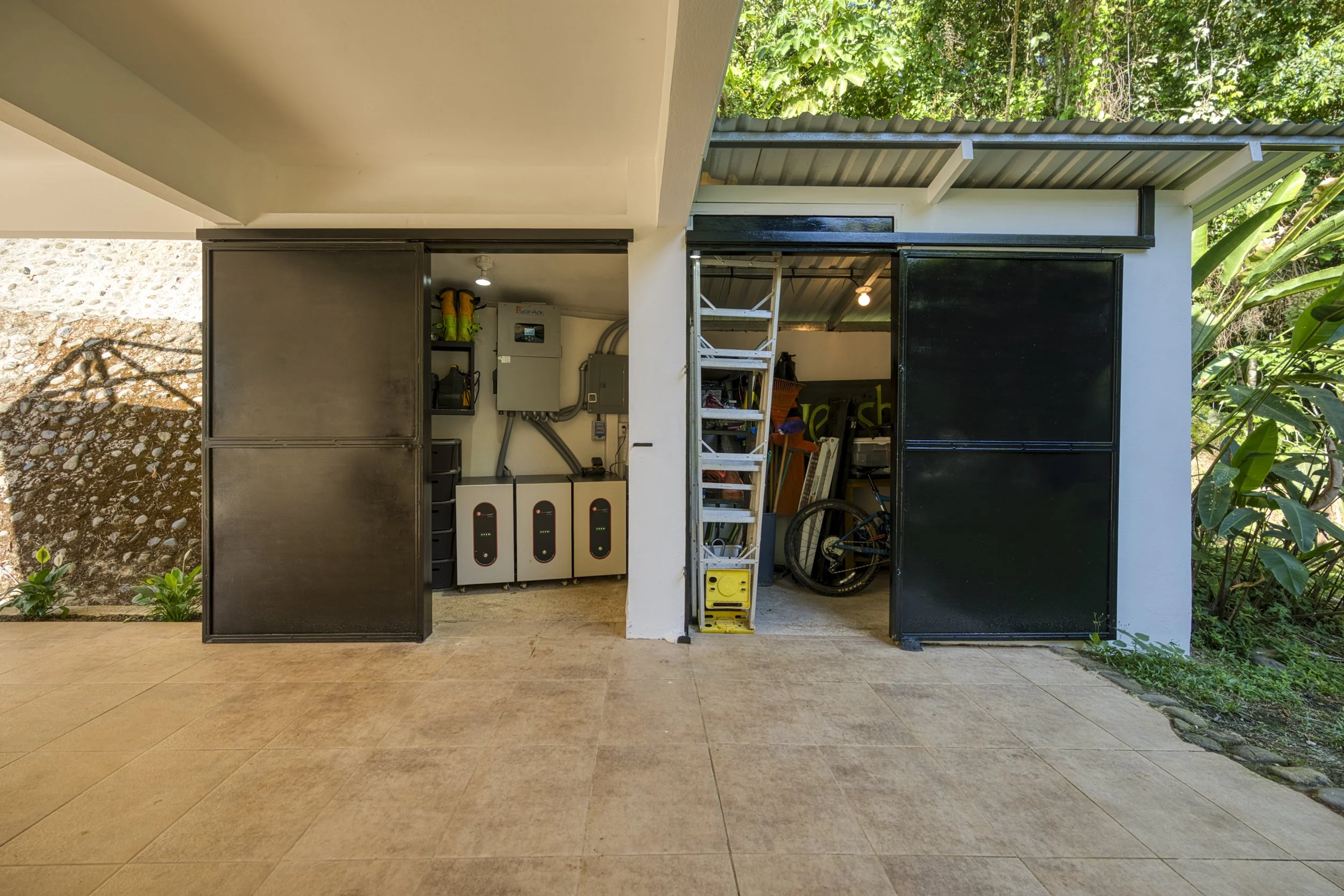 Solar power infrastructure providing energy independence at Casa Arbol de Vida. The outdoor solar closet is insulated and humidity controlled; the other outdoor storage is ideal for tools and ladders. Lockable steel doors provide security.