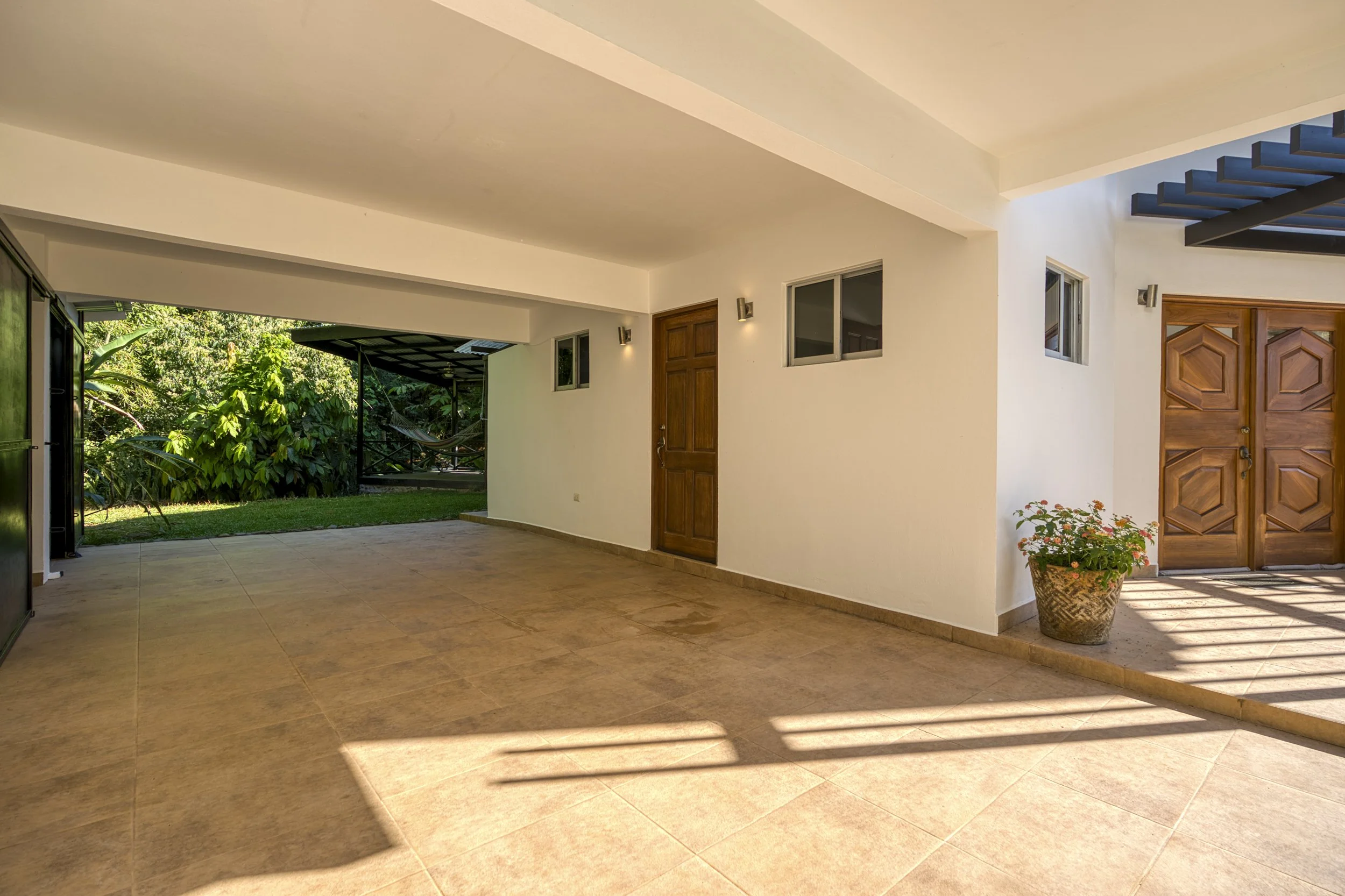 Carport entrance leads to kitchen highlighting the functionality of Casa Arbol de Vida. Perfect for rainy days and protecting vehicles. This area could also serve as a secondary outdoor entertainment area.