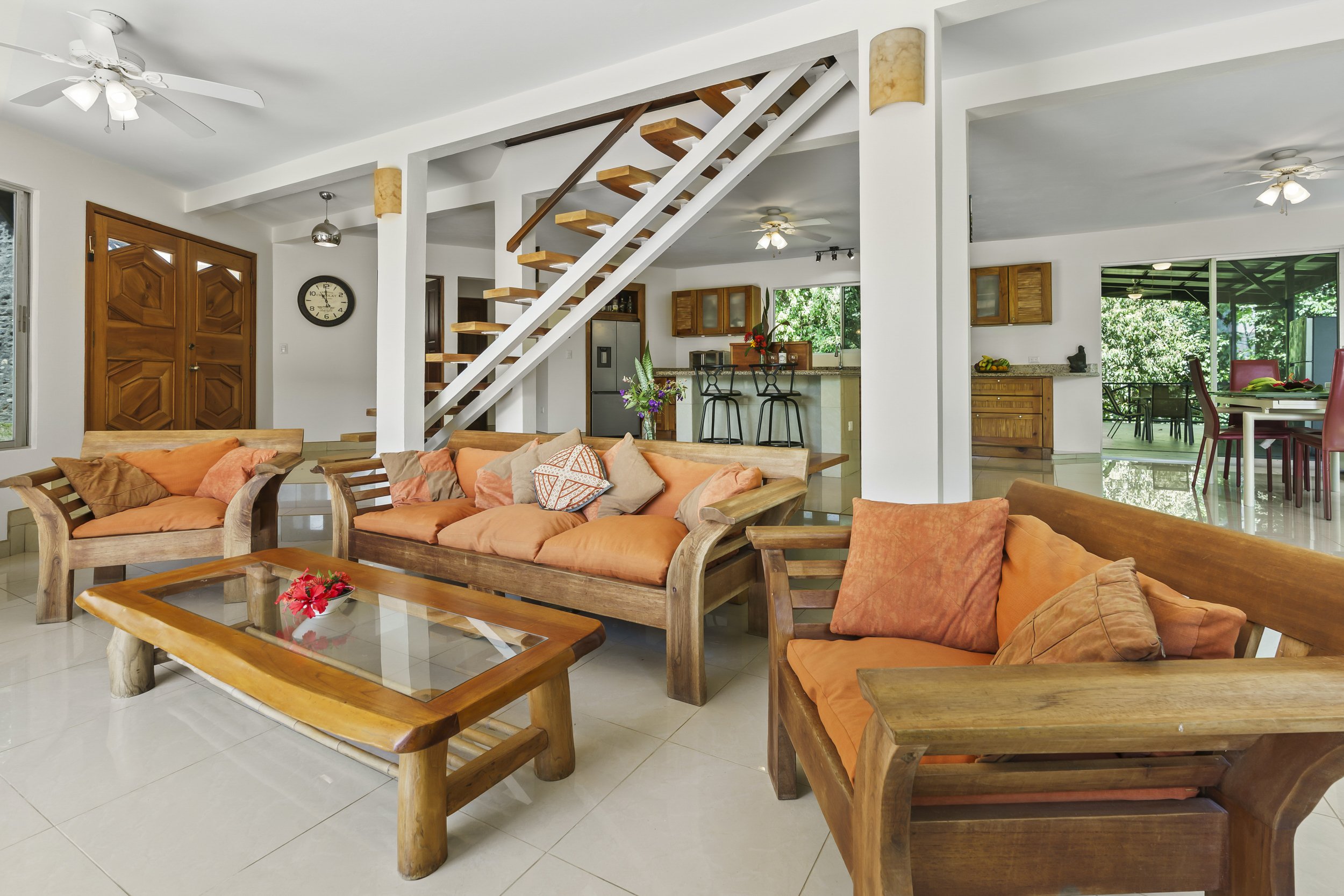 Spacious living area inside Casa Arbol de Vida jungle home near Dominical Costa Rica. Here you can also see the main entrance - double cedar doors artfully created to reflect design details of the home.