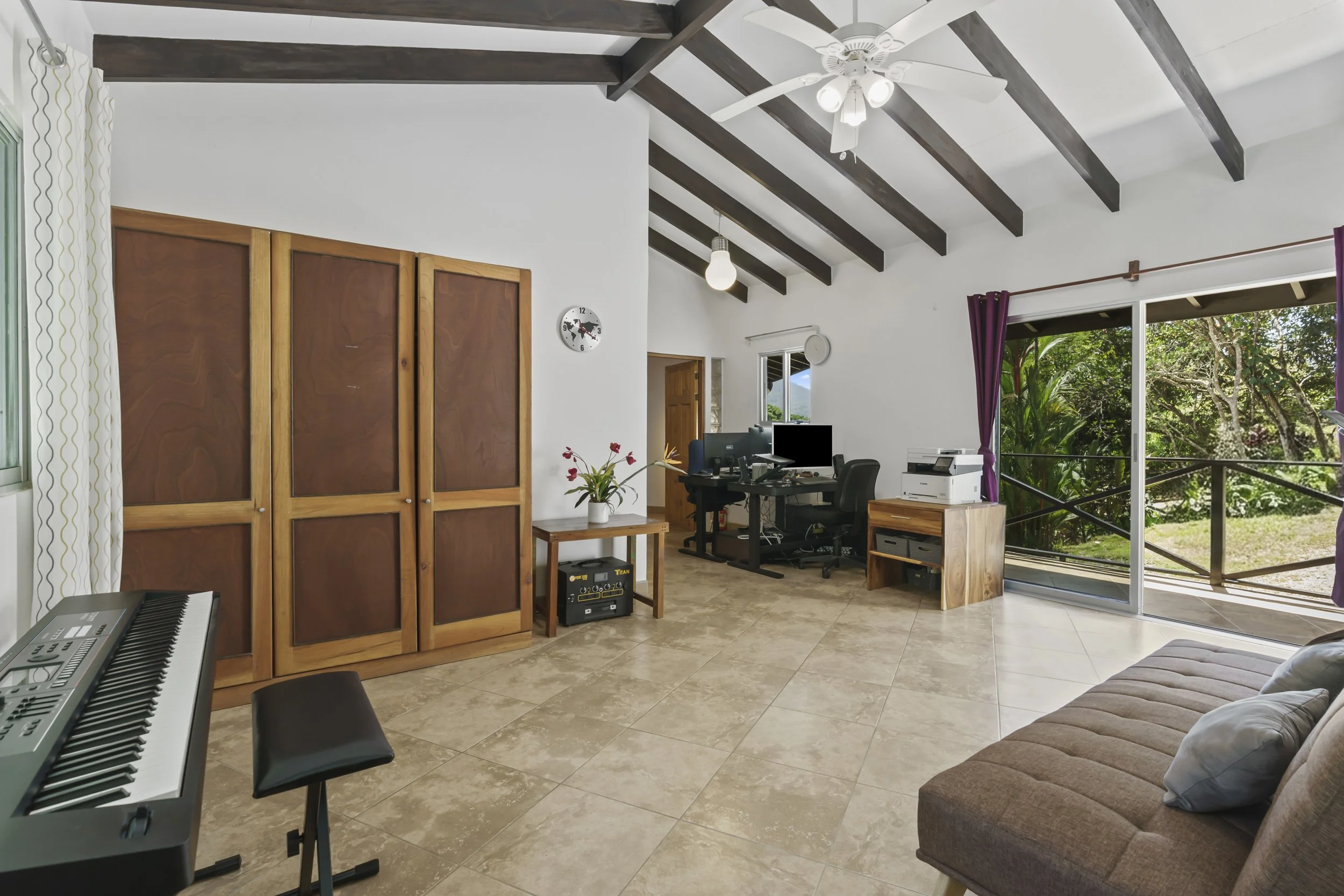 Massive primary suite highlighting the open layout and built in wood closet. Vaulted ceilings with tropical beams are expansive.