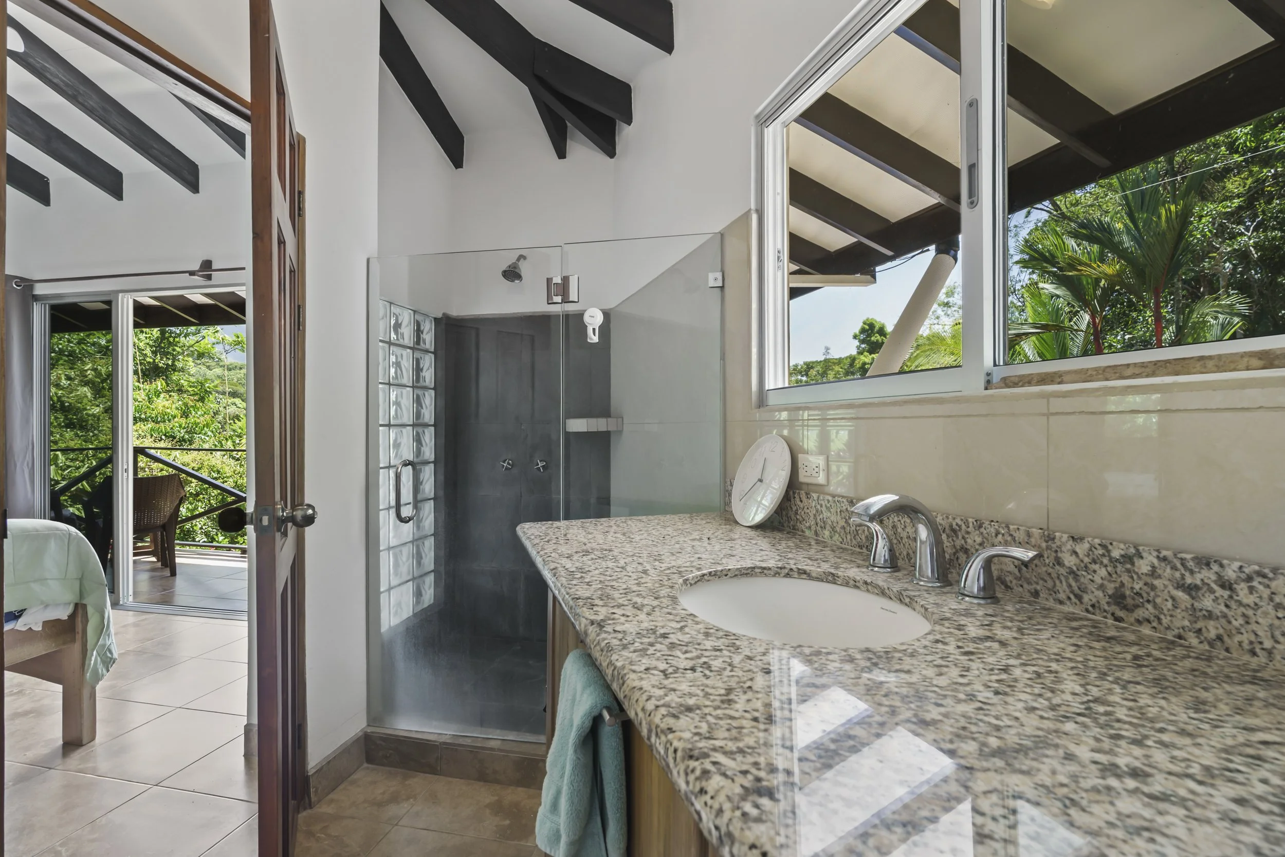 Secondary primary suite bathroom with spacious shower design, natural light and functional layout.