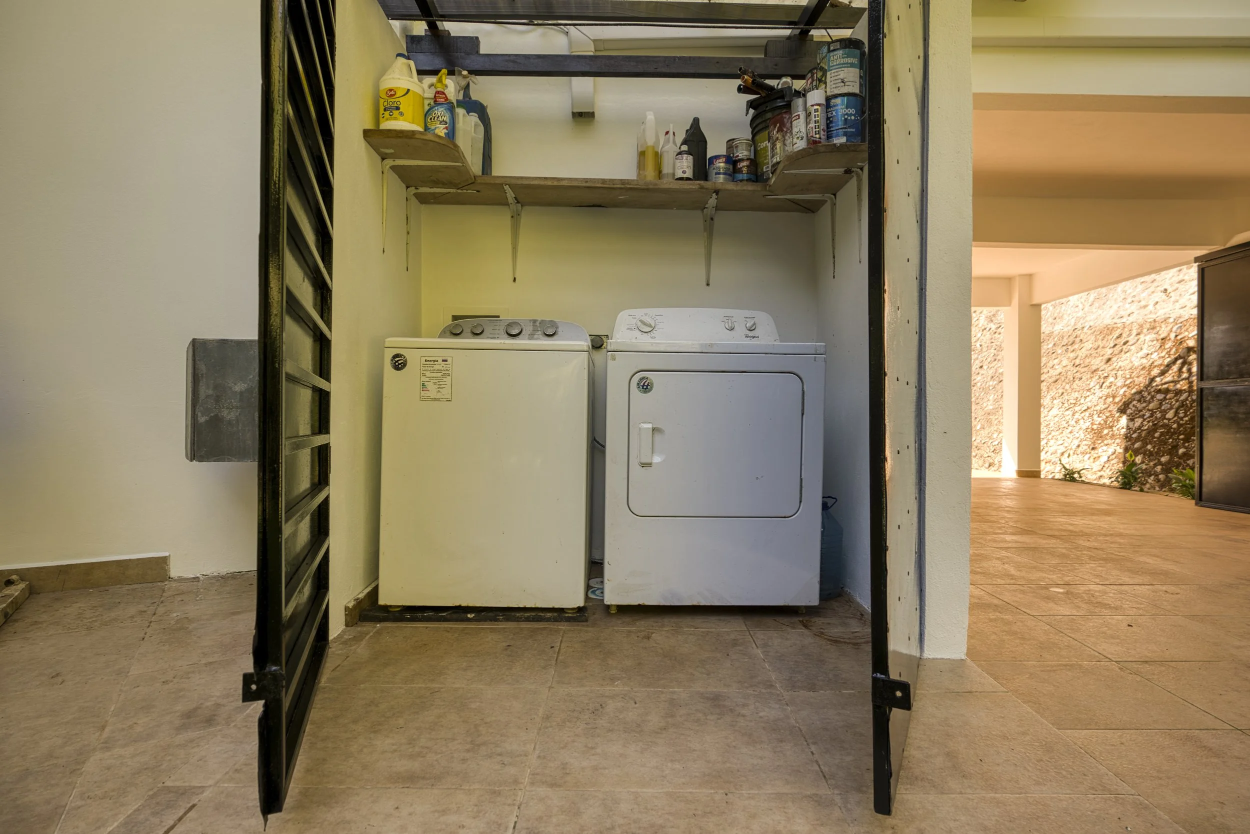 Outdoor washer and dryer with lockable steel doors. Additional storage area above. There is an outdoor sink situated outside on the left.