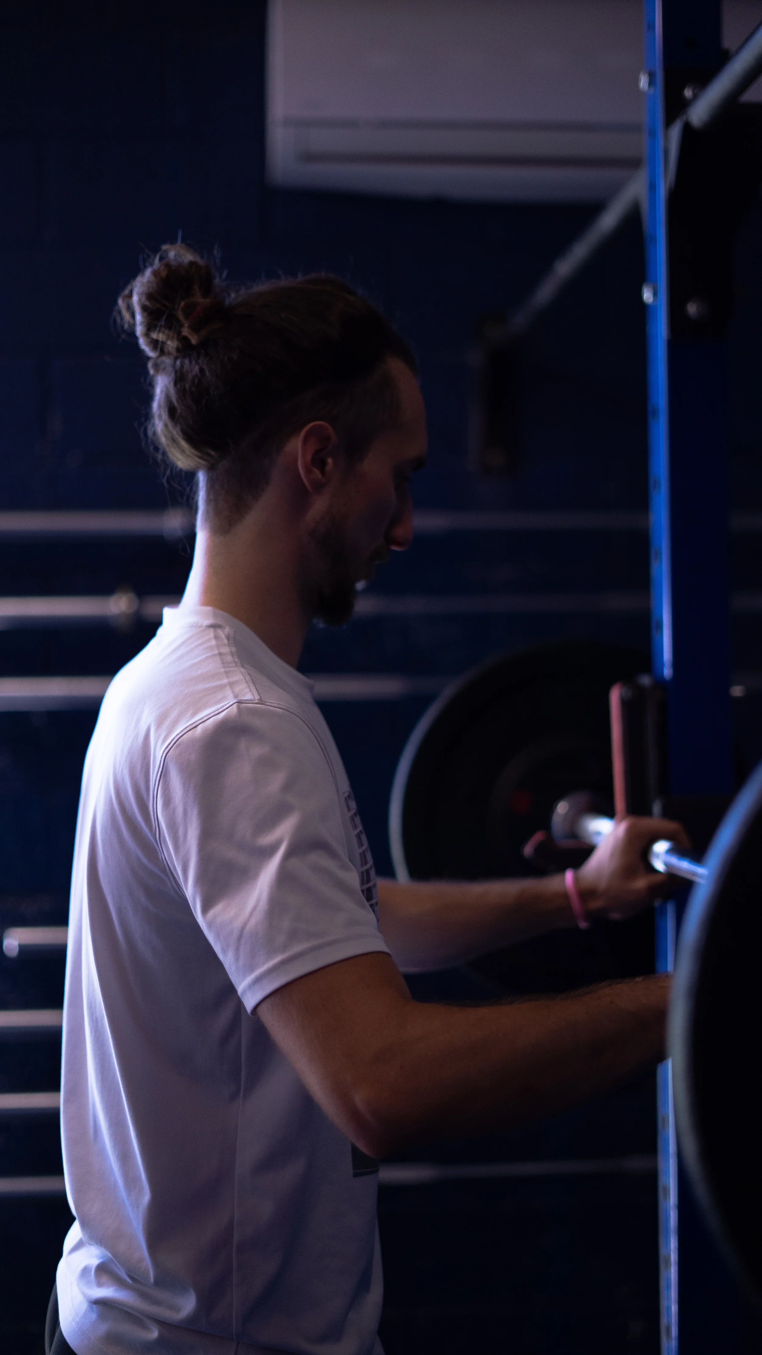 Le coach charge un disque sur une barre de musculation