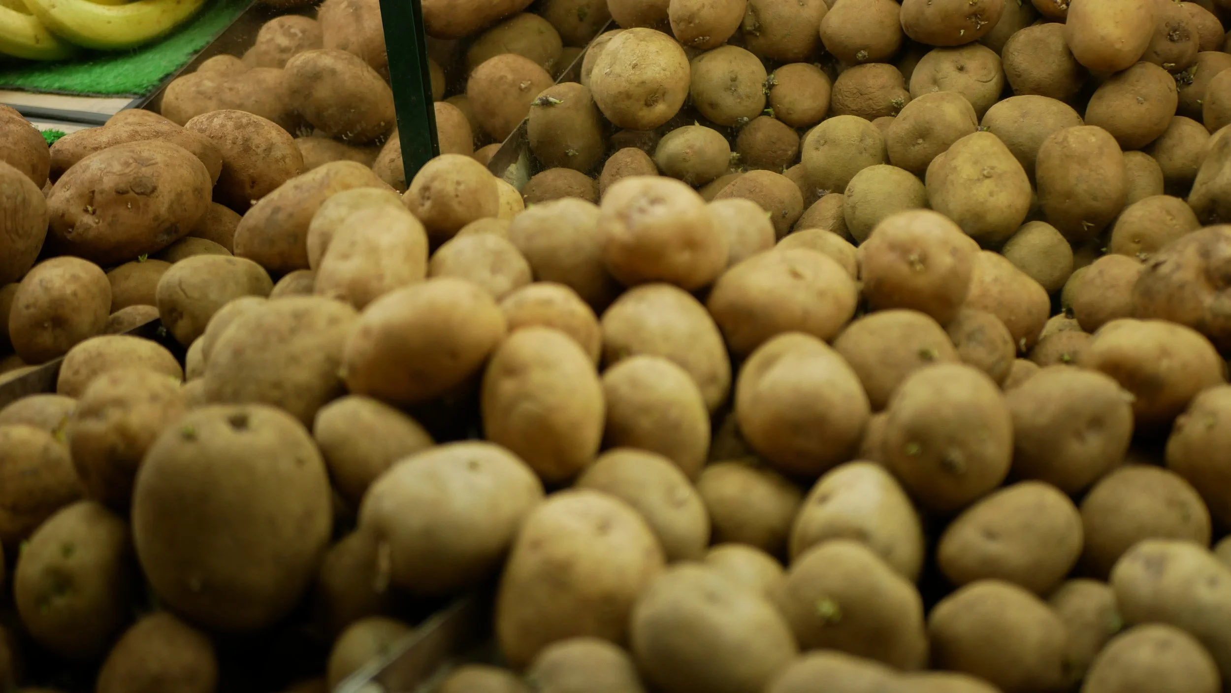 Pile of fresh potatoes in a supermarket display.