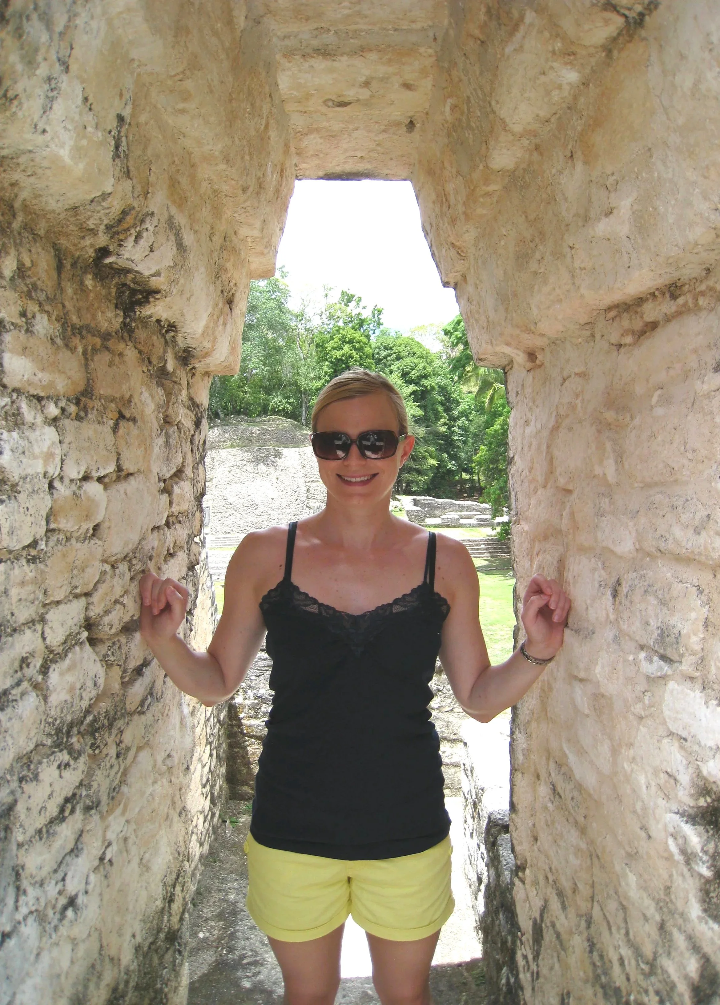 A photo of Anne Bettesworth standing between ruins in Caracol, Belize
