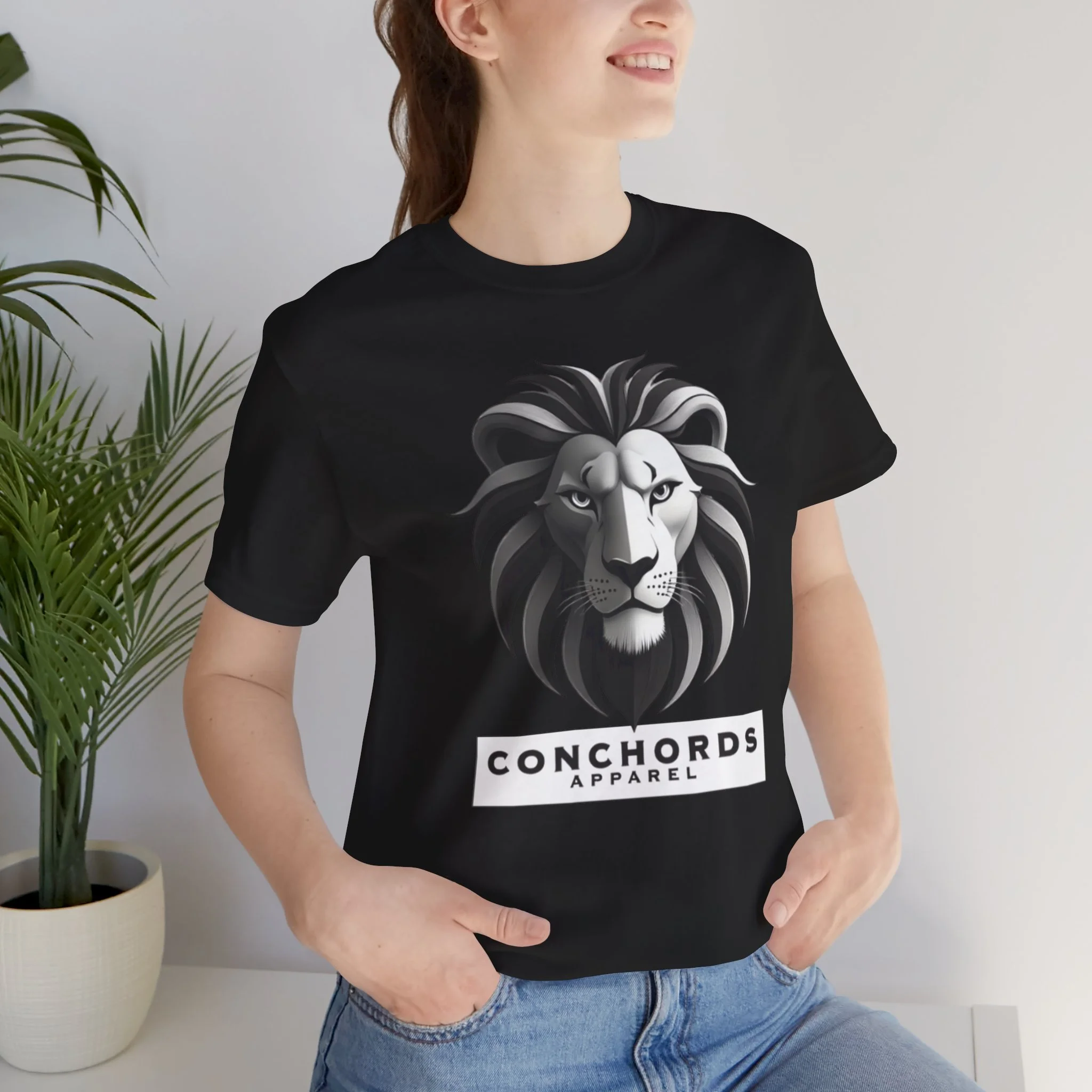 A woman wearing a black T-shirt with a graphic of a lion's face and the text 'CONCHORDS APPAREL' underneath.