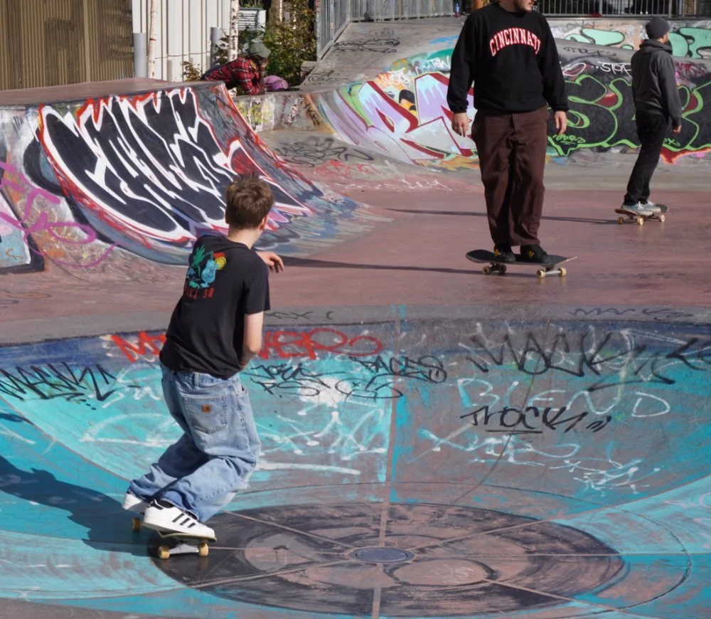 Skateboarders practising together at a skate park, representing community, creativity and youth empowerment.