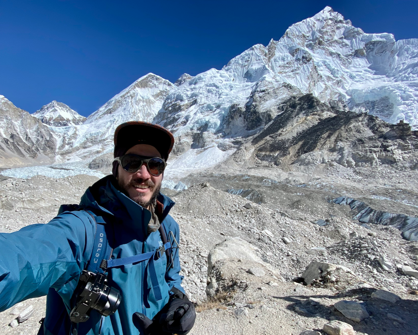 A man taking a picture at Everest Base Camp from the Kalapatar view. An amazing hike and adventure where Andres can take you. The Nepali Himalayas is an amazing place to trek.