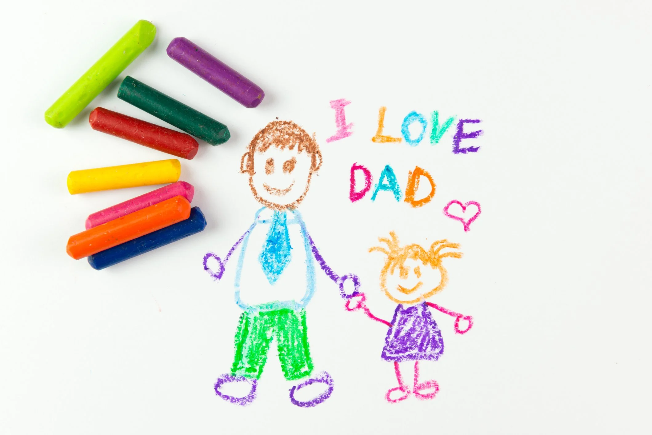 Colorful drawing of a father and daughter holding hands, with the words "I LOVE DAD" and a heart and smiley face, surrounded by crayons.