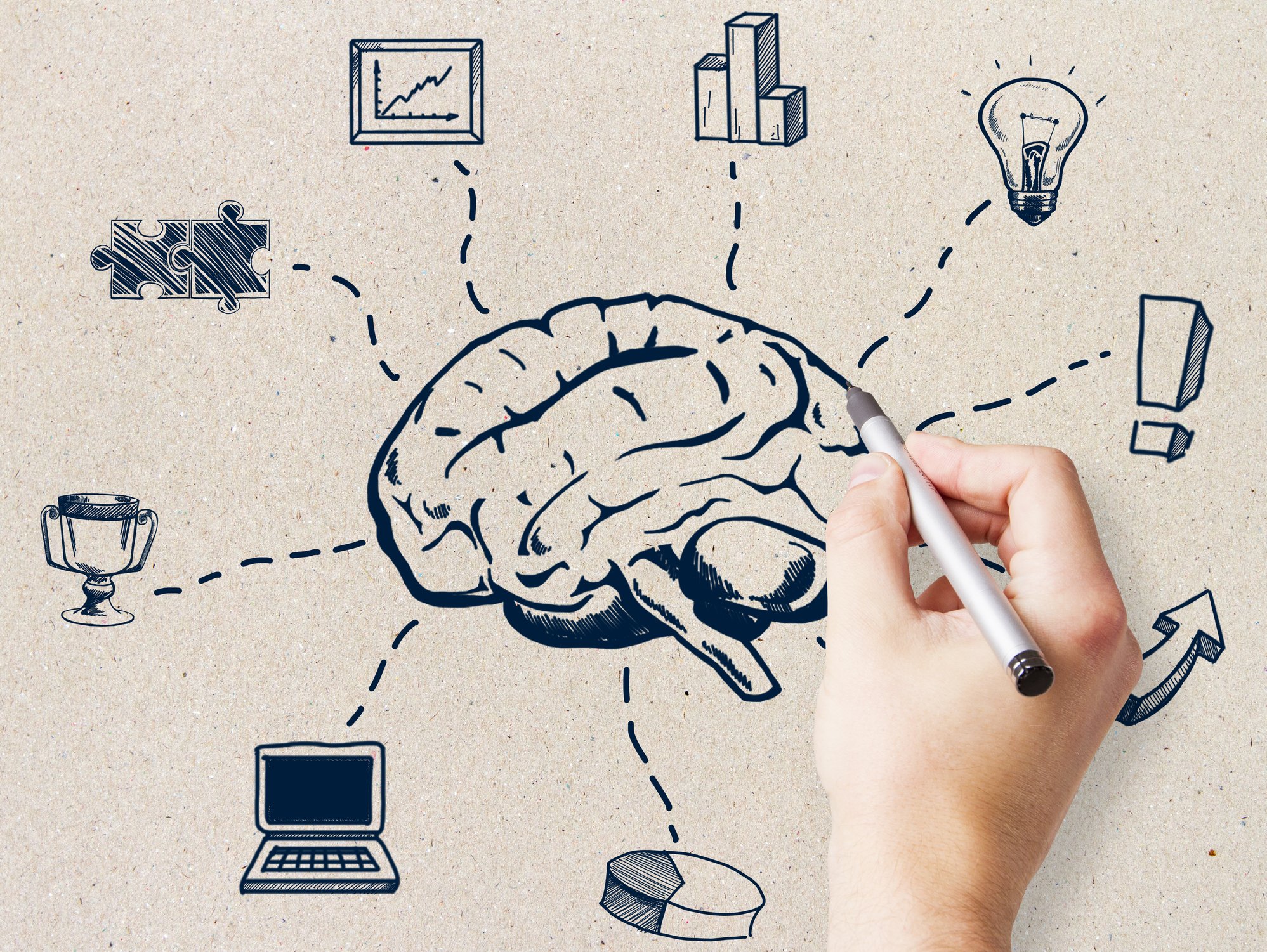 Hand drawing a brain with various related icons around it, including a graph, puzzle pieces, a light bulb, a trophy, a laptop, a 3D bar chart, an exclamation mark, and an arrow, on a textured background.