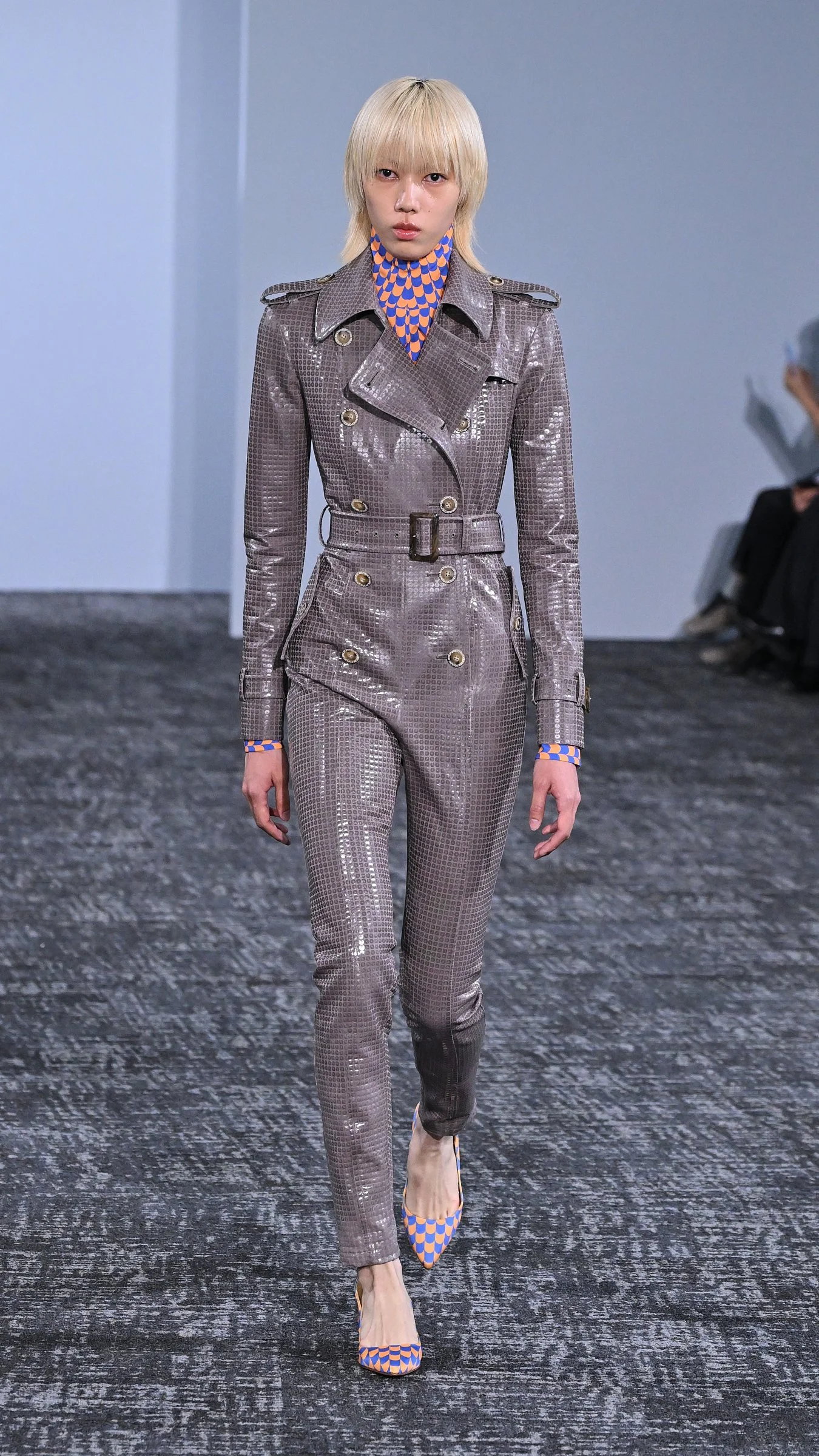 Mannequin en combinaison ajustée taupe sur le podium du défilé Anrealage printemps-été 2027 à Paris.