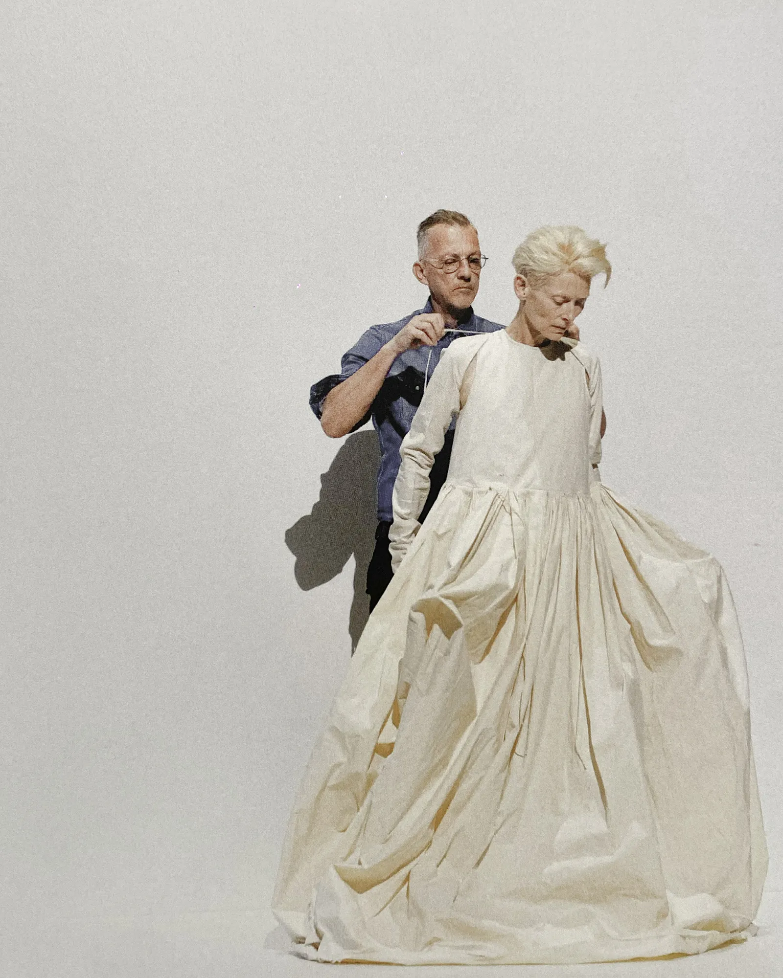 Olivier Saillard pose un vêtement sombre sur les épaules de Tilda Swinton pendant House of Gestures.