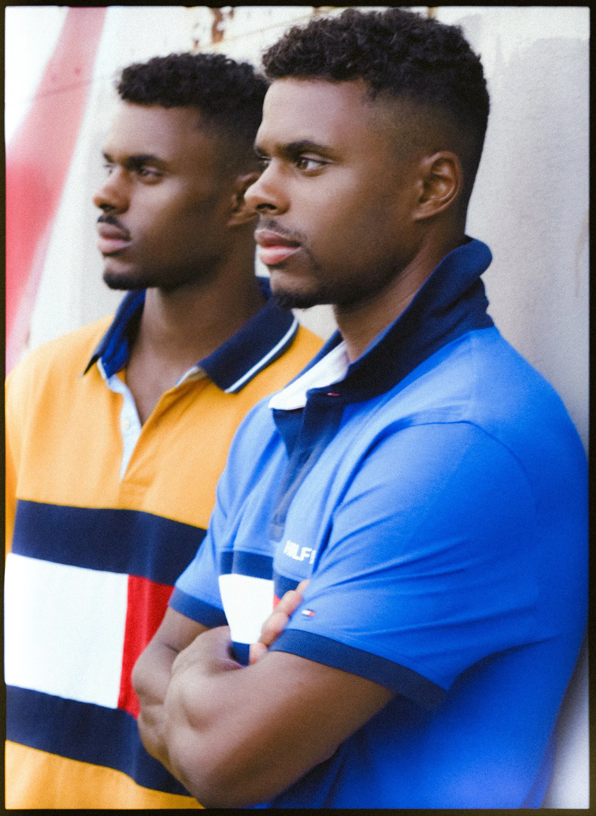Charles et Maxence Bertimon côte à côte en polos jaune et bleu, les regards tournés dans la même direction.