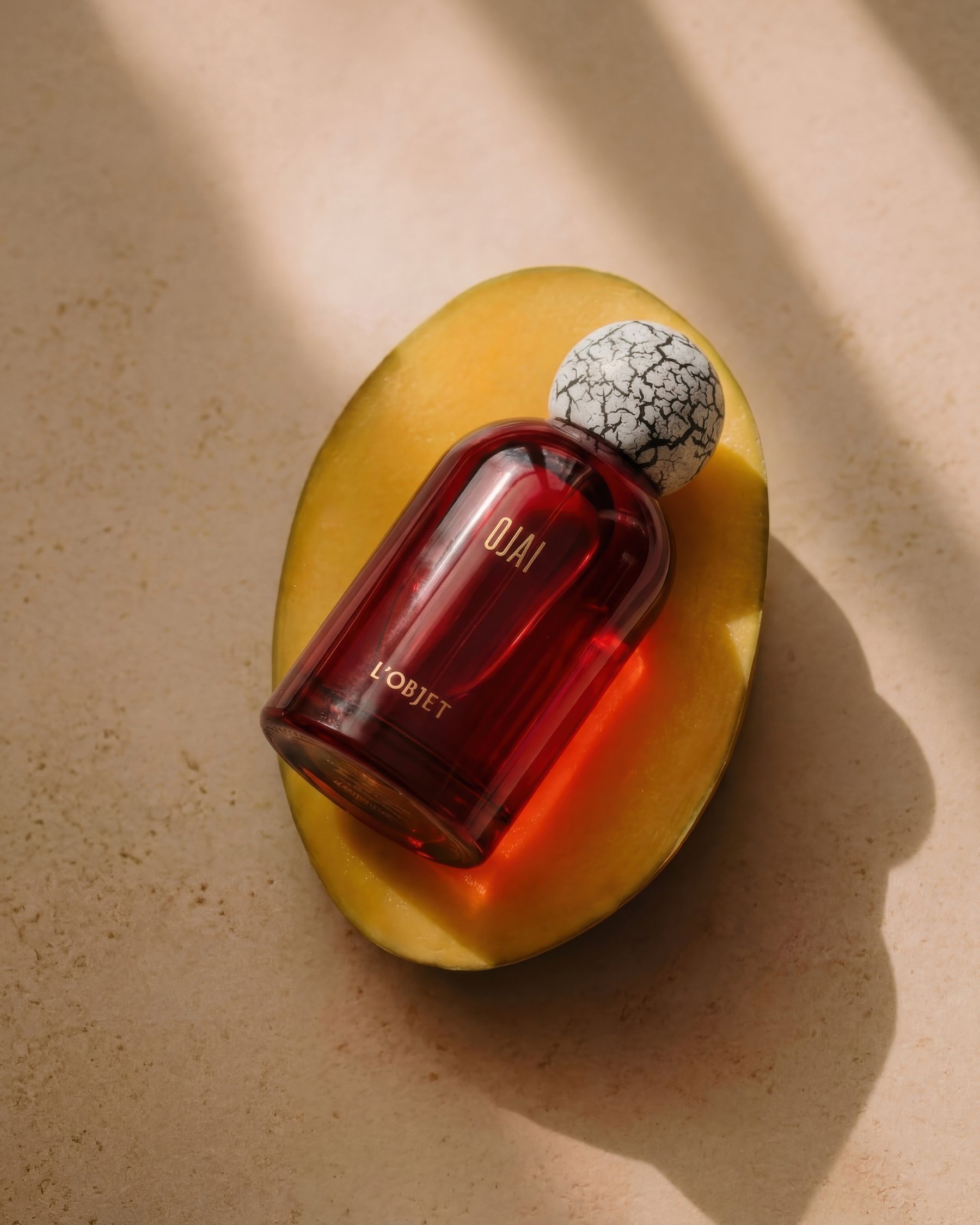 Composition orangée évoquant la mangue, le safran et la lumière dorée du parfum Ojai de L’OBJET.