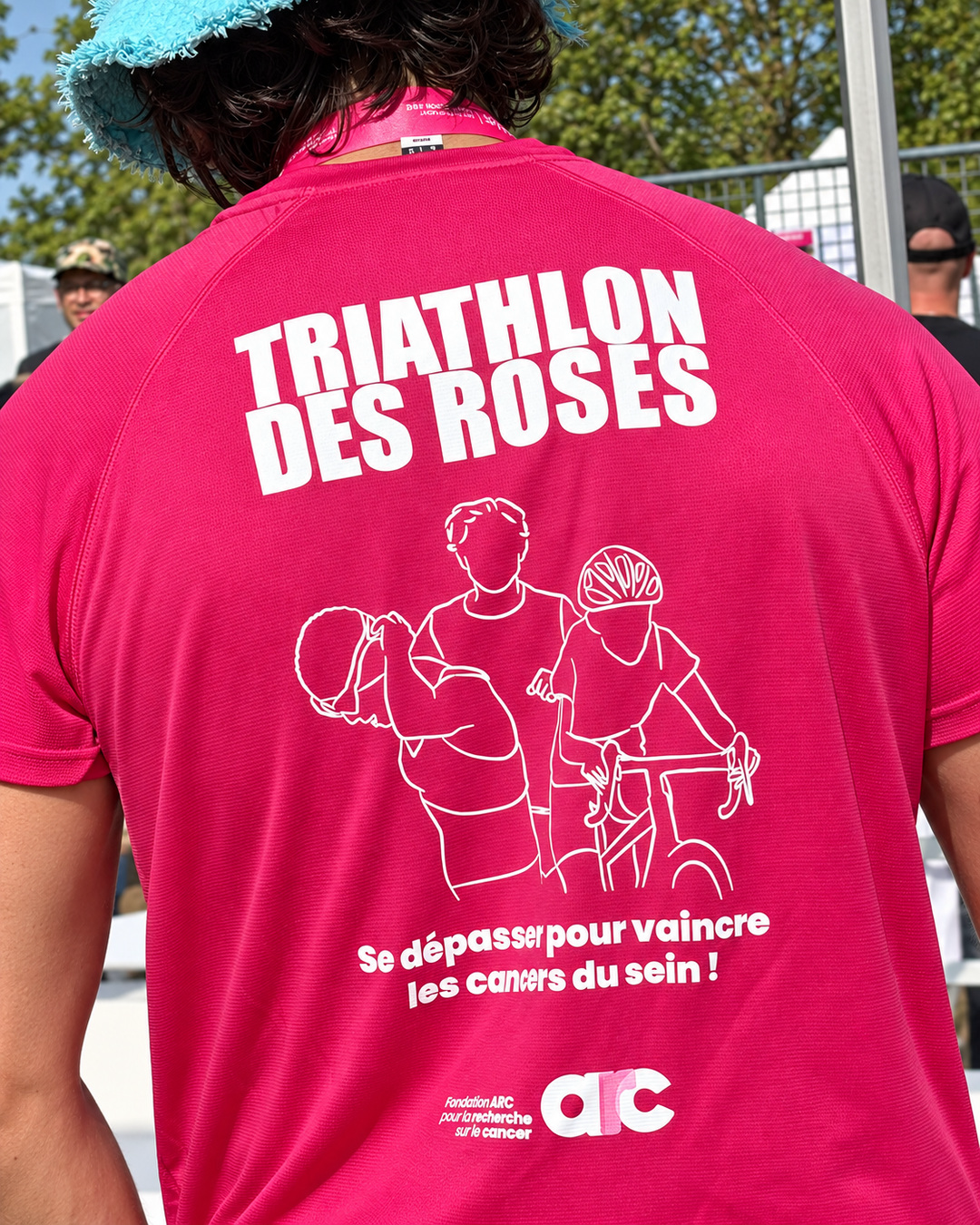 Dos d’un tee-shirt rose portant le message « Triathlon des Roses » et le logo de la Fondation ARC.
