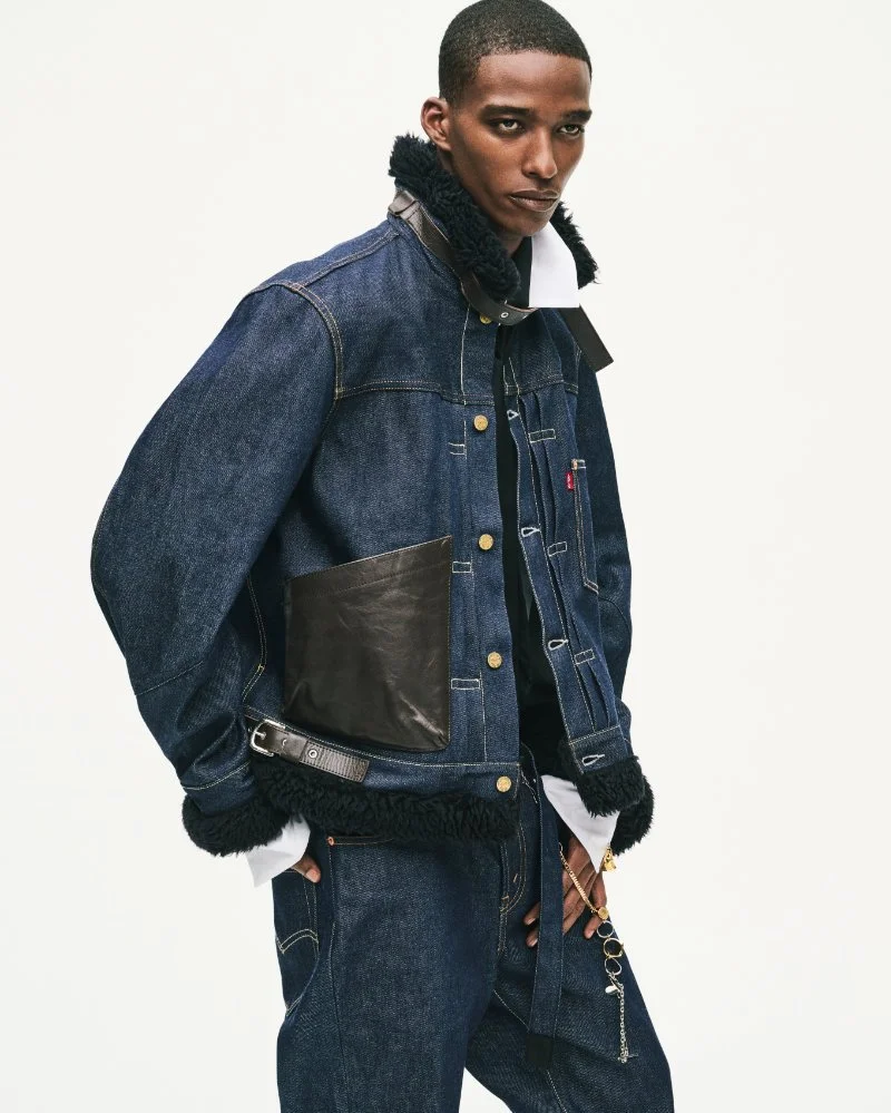 Mannequin portant une veste Levi’s x sacai en denim indigo, avec bordures sherpa foncées et grande poche en cuir, sur fond clair.