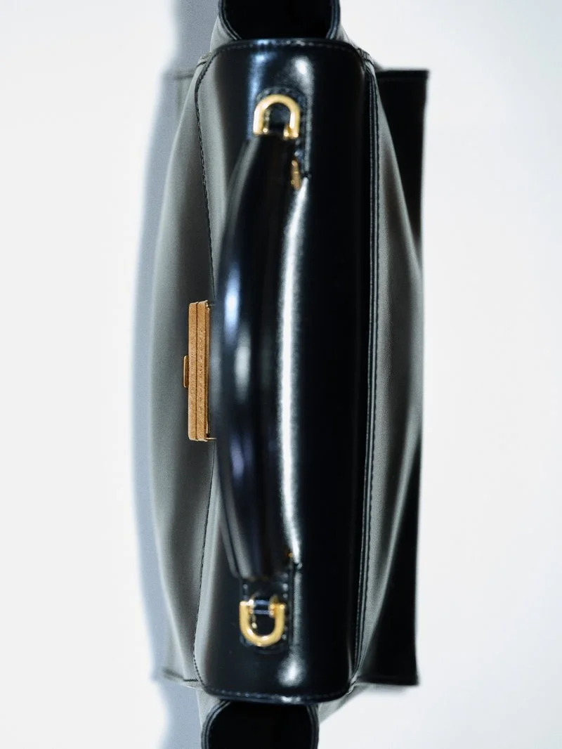 Vue du dessus du sac Balenciaga Hourglass Avenue noir montrant son volume, son soufflet et ses doubles poignées.