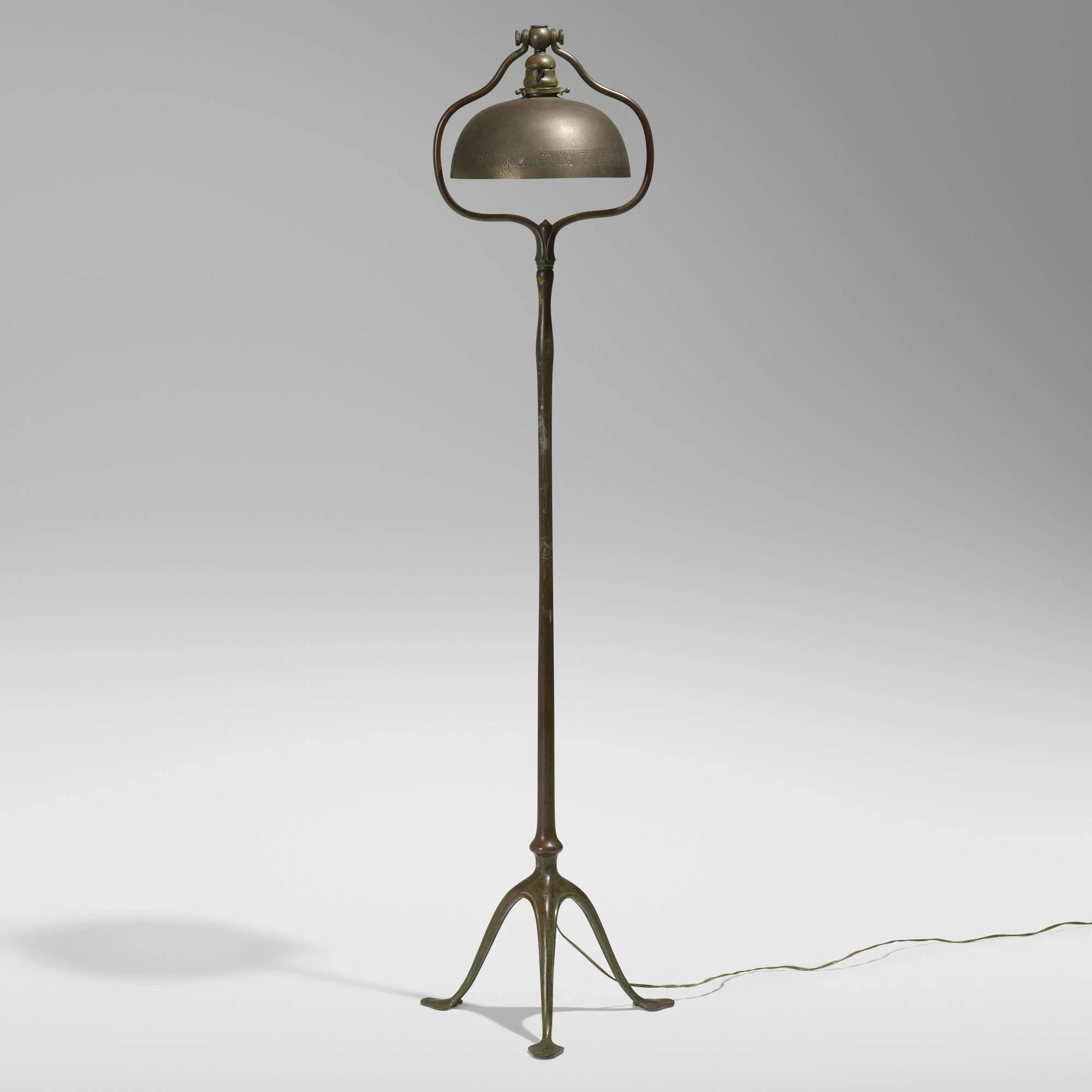A vintage floor lamp with a metal shade on a gray background.