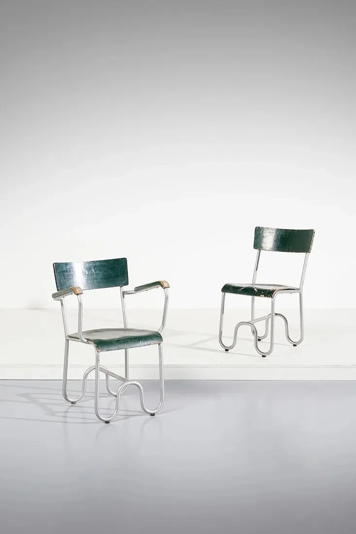 Two vintage metal chairs with green seats and backrests, featuring unique curly metal legs, placed on a white surface against a plain white background.