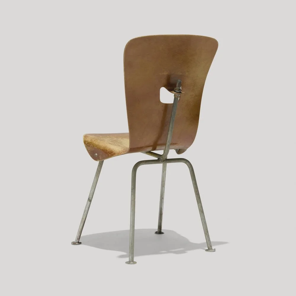 An old wooden school chair with a metal frame and swivel mechanism against a plain background.