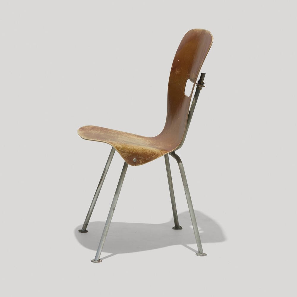 A vintage brown wooden chair with metal legs and a backrest, set against a plain light gray background.