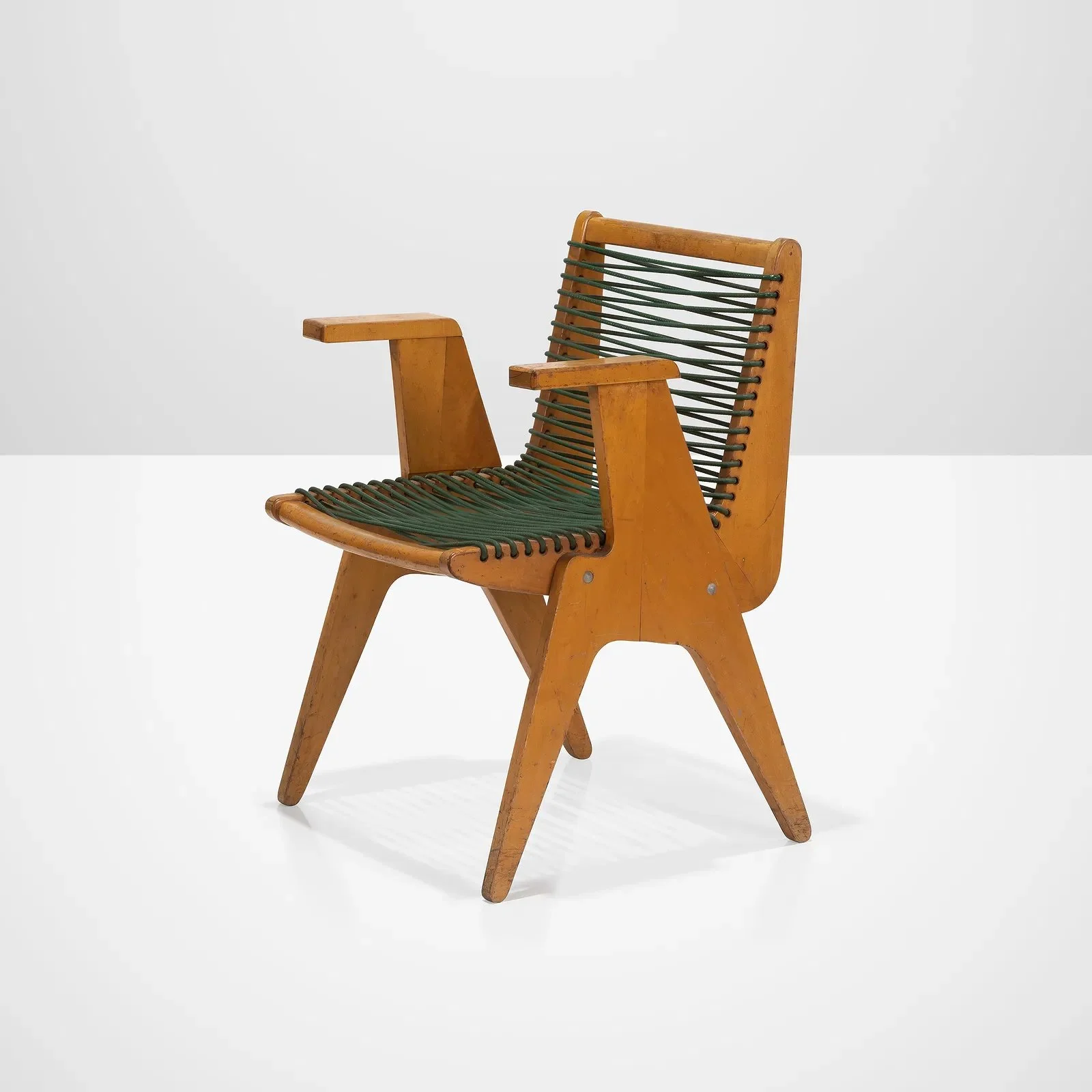 Mid-century modern wooden lounge chair with green woven seat and backrest, set against a plain white background.