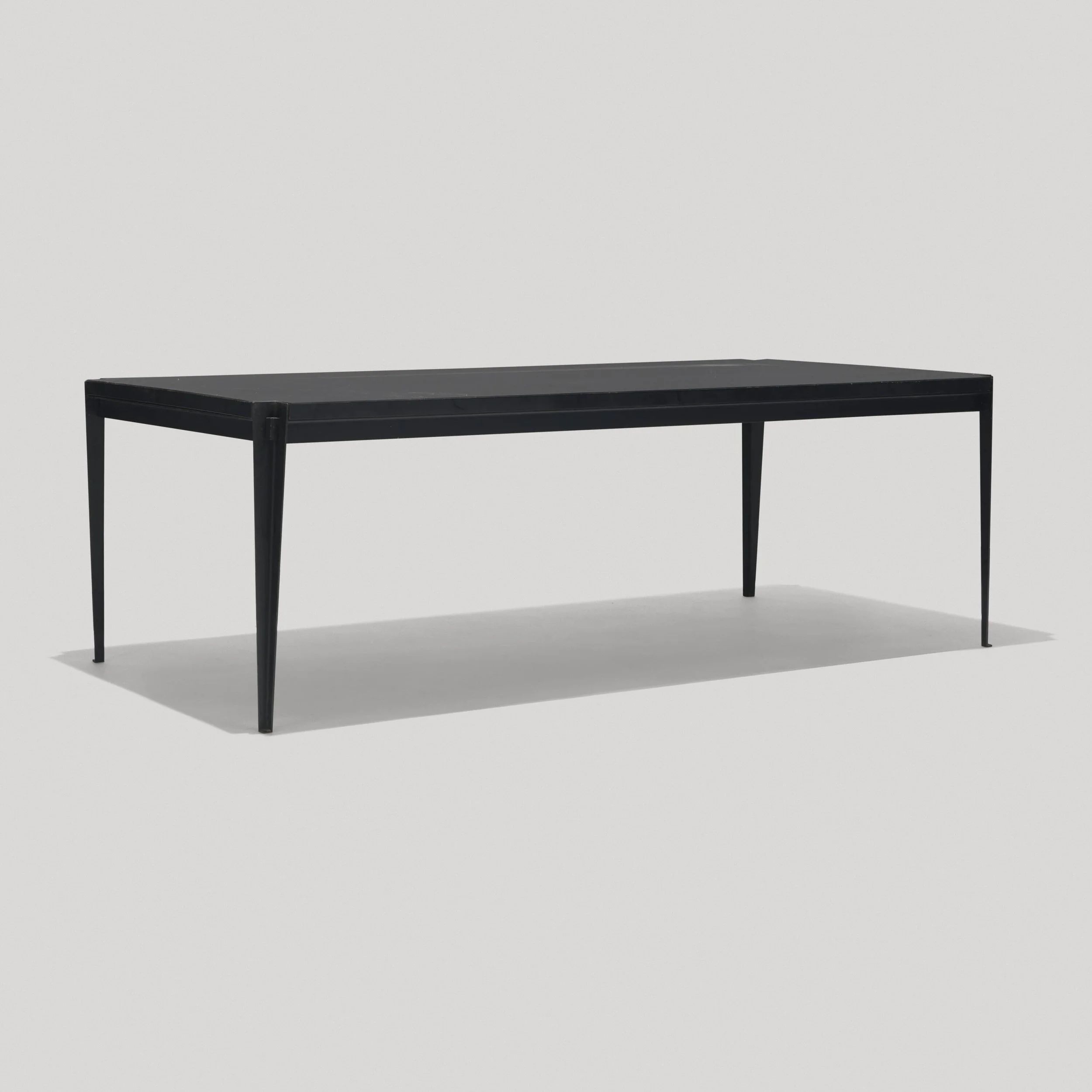 A minimalist black table with a flat surface and four thin legs set against a plain white background.