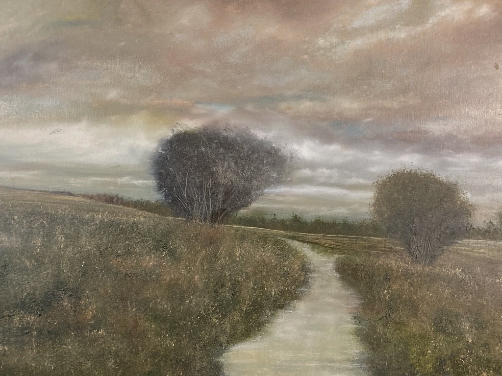 A tonalist landscape featuring a winter field and trees under a dramatic sky.