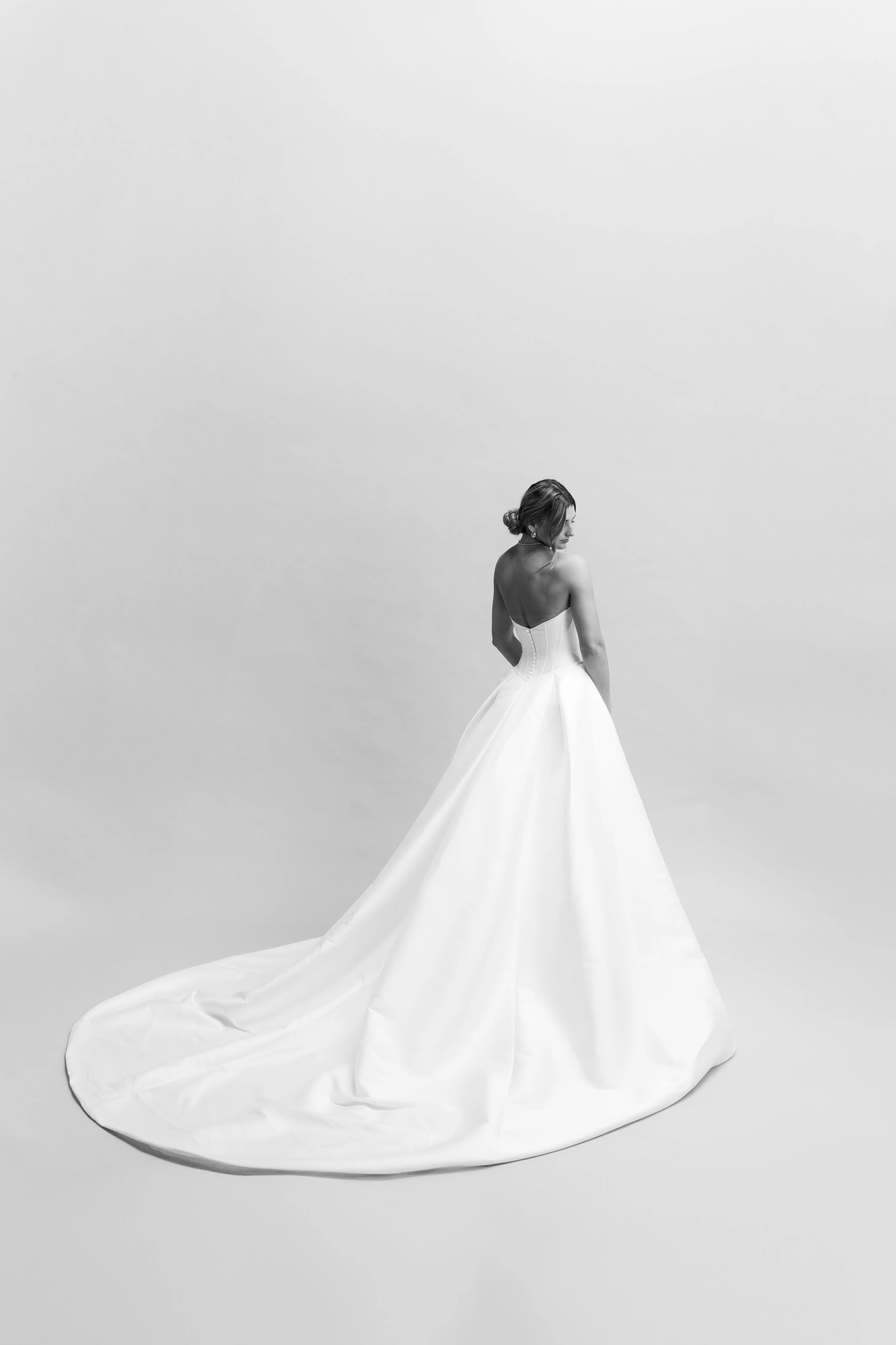 Bride looking over shoulder in birdal session against seamless editorial backdrop in Los Angeles. Shot by Lillee Monet Photography