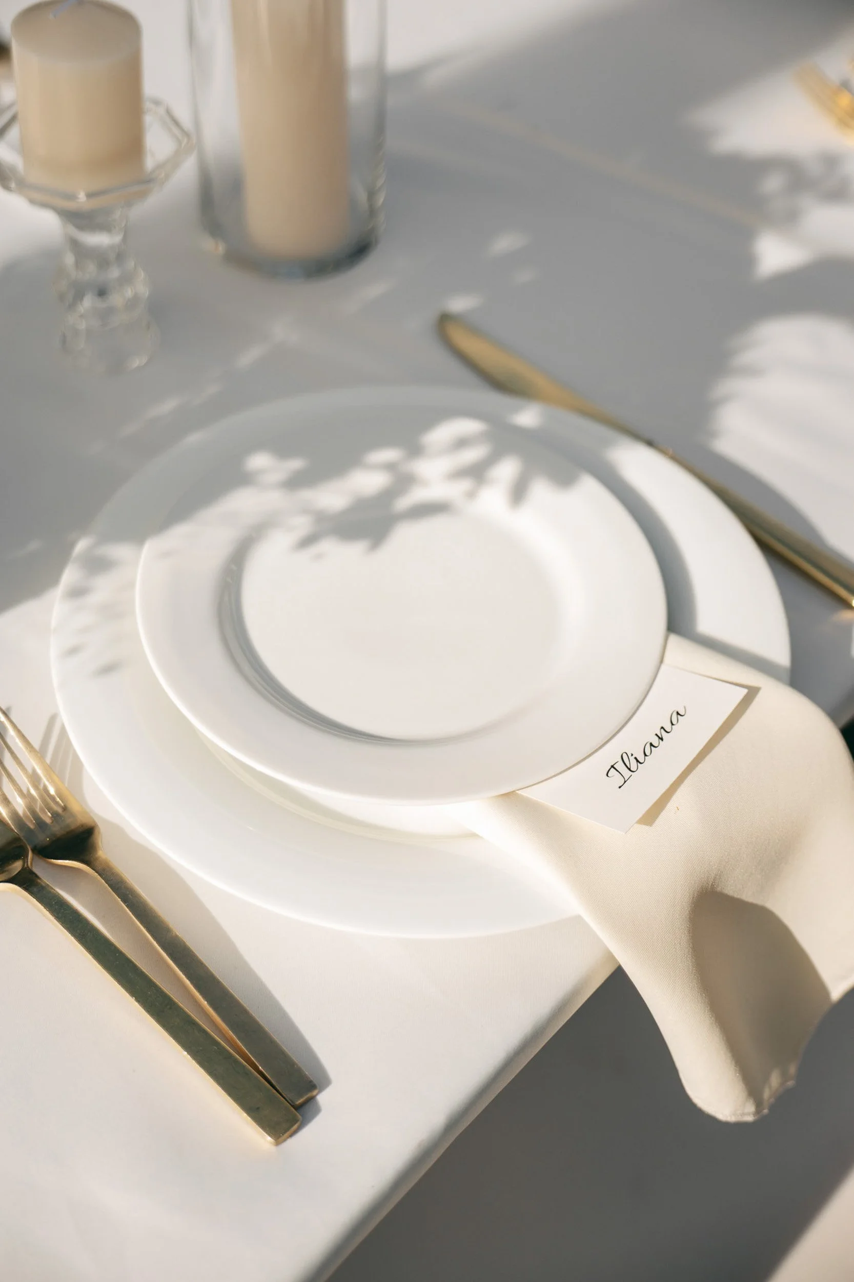 Editorial wedding tablescape featuring elegant place settings, candlelight, and refined reception details.