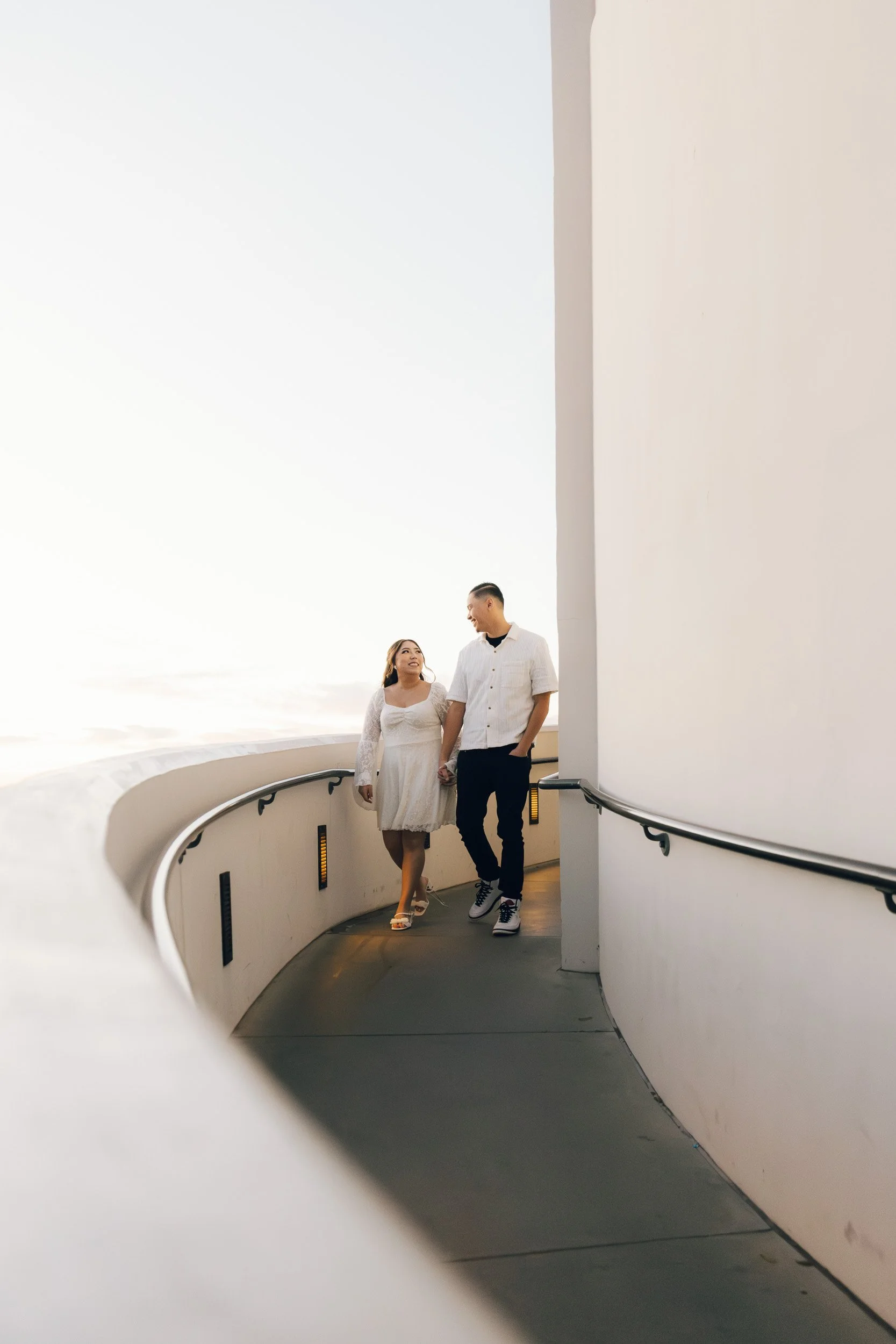 Couple walking together during an engagement session at Griffith Observatory overlooking Los Angeles.