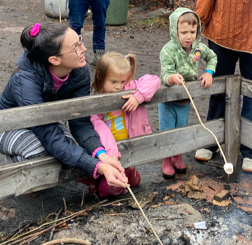 Josephine helping a student with marshmallow roasting on one of our field trips