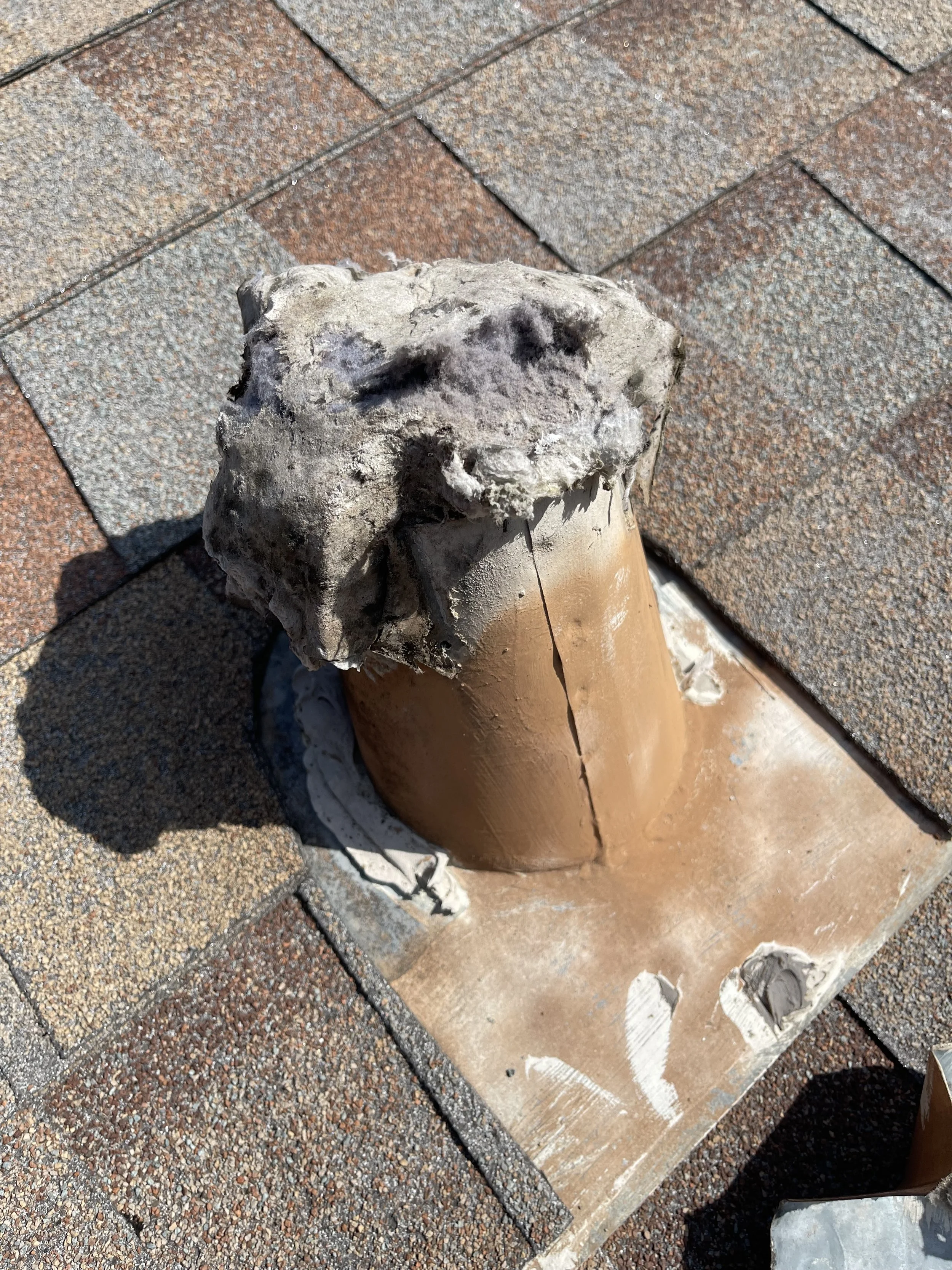 A construction worker is holding a trowel with cement, working on a brick wall. Tiles are laid on the ground nearby.