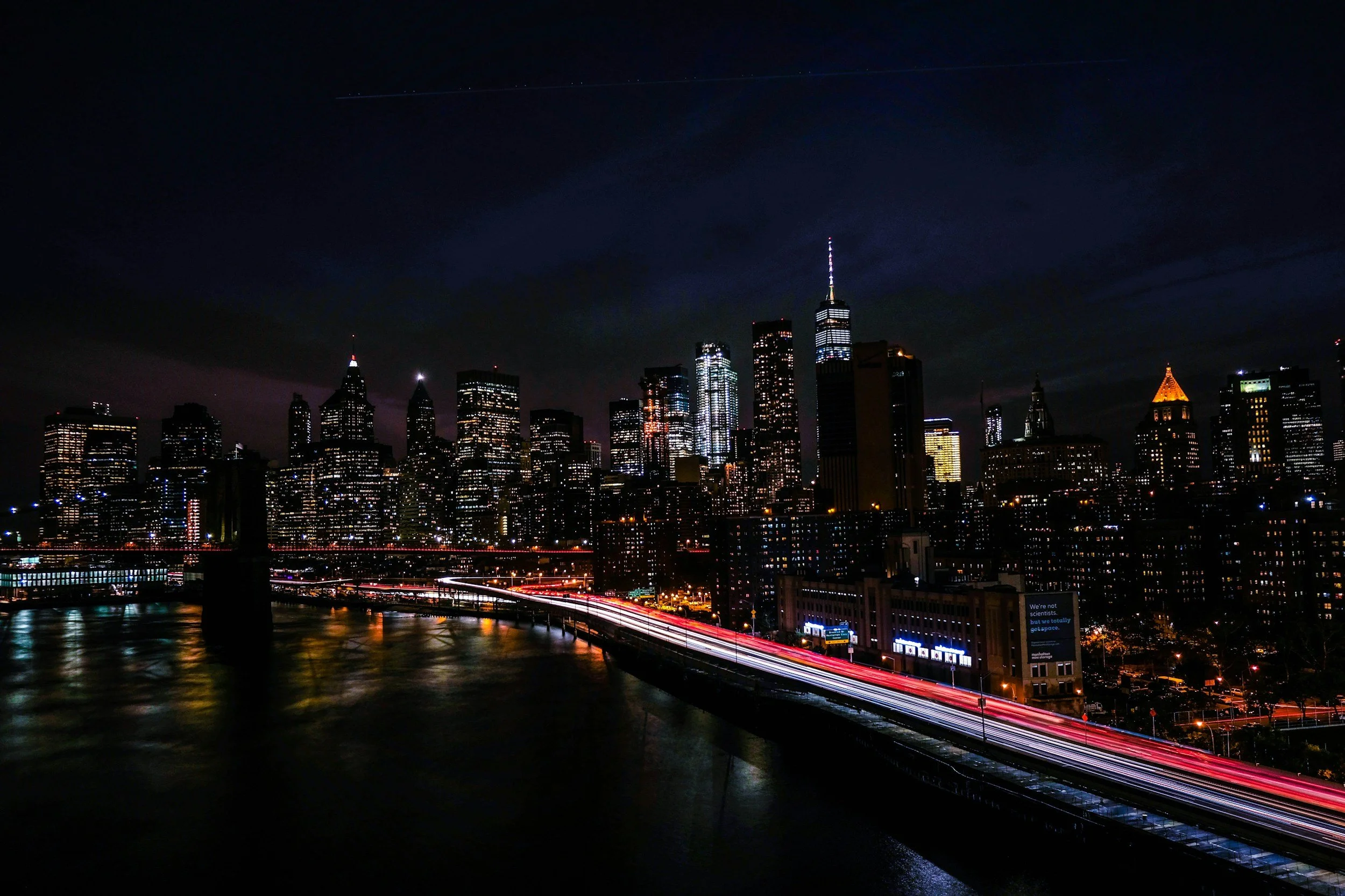 Night city skyline with illuminated skyscrapers and traffic flows, representing global markets, financial activity and continuous business risk exposure.