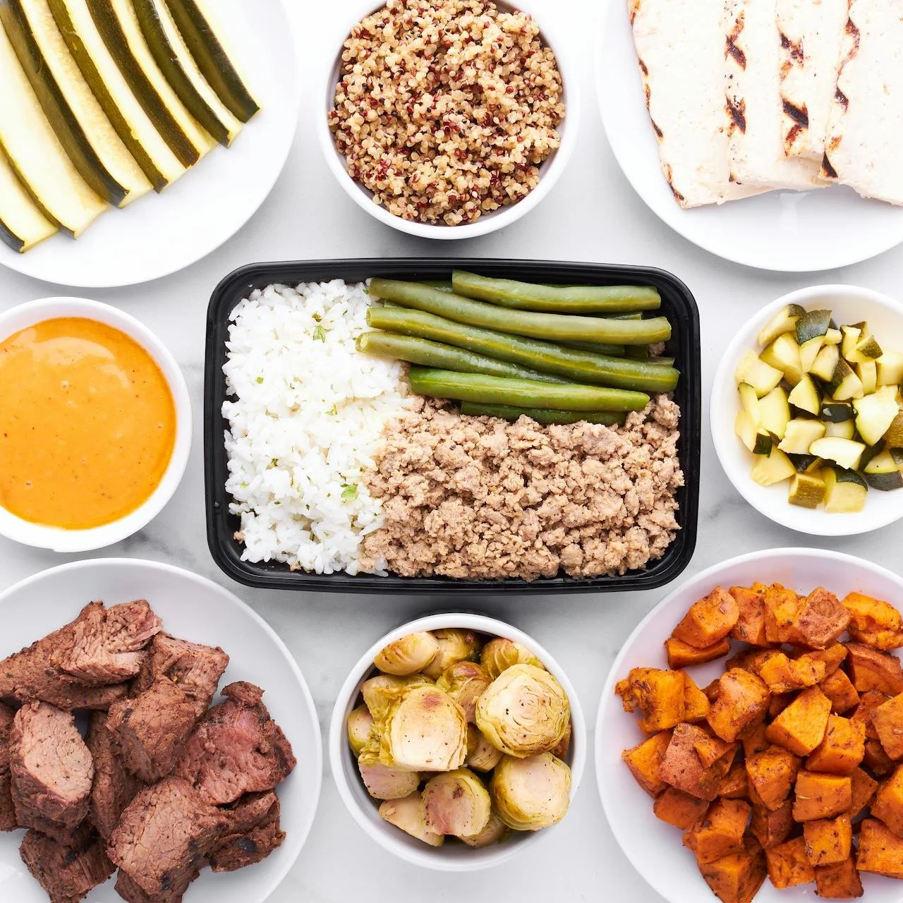 Overhead flat lay of meal prepped protein vegetables and grains in bowls representing a balanced nutrition plan and diet and workout plan. Photo by Justin Doherty on Pexels