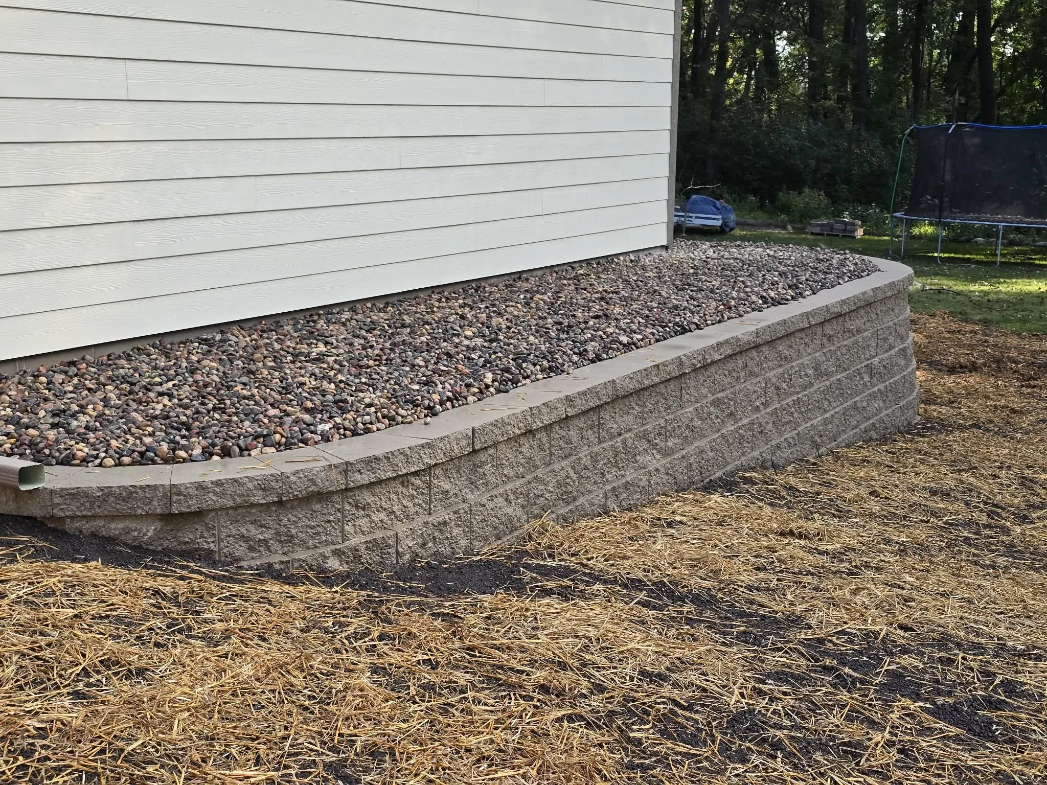 segmental retaining wall along house foundation landscape support