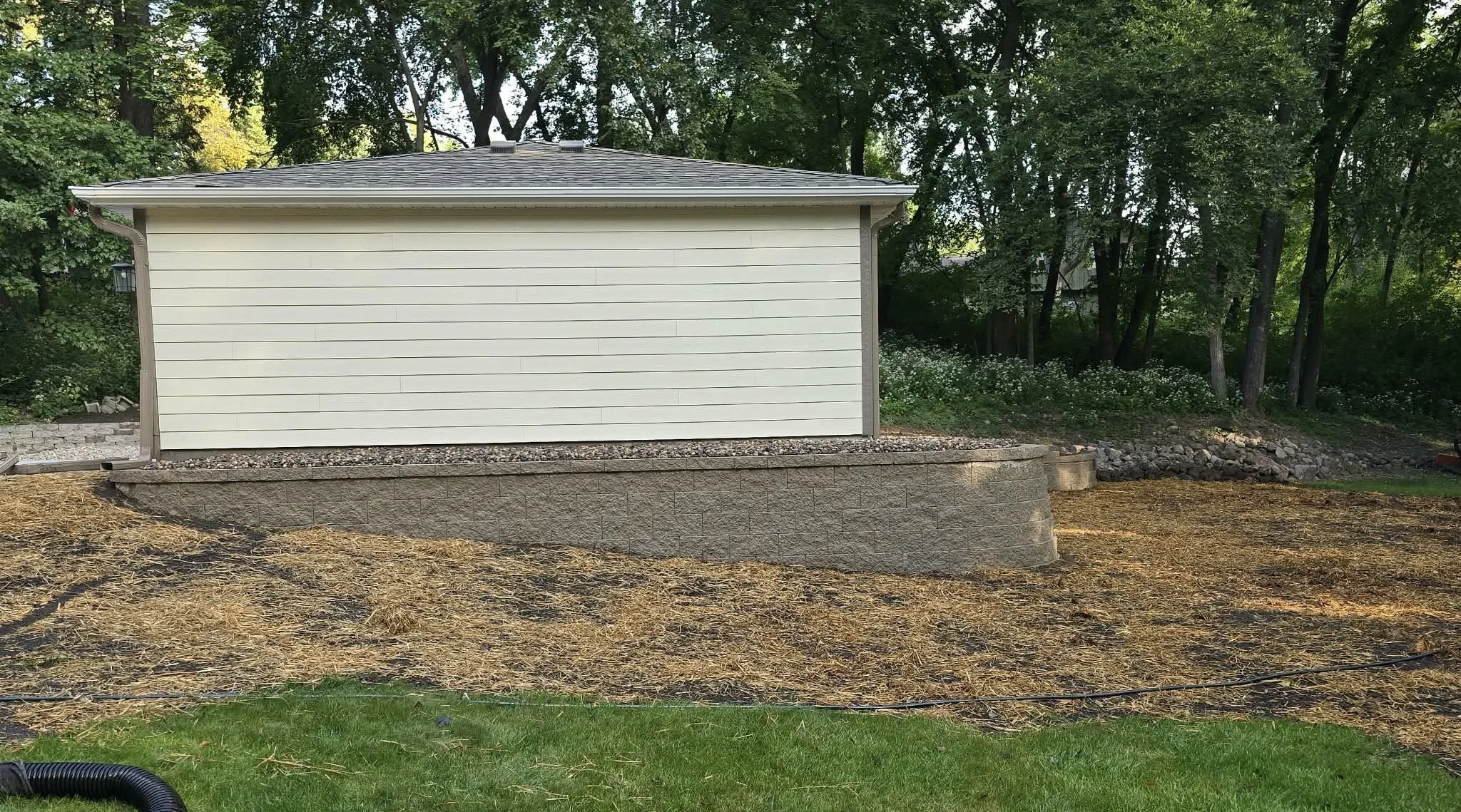 retaining wall construction near garage with proper grading Maple Grove Minnesota