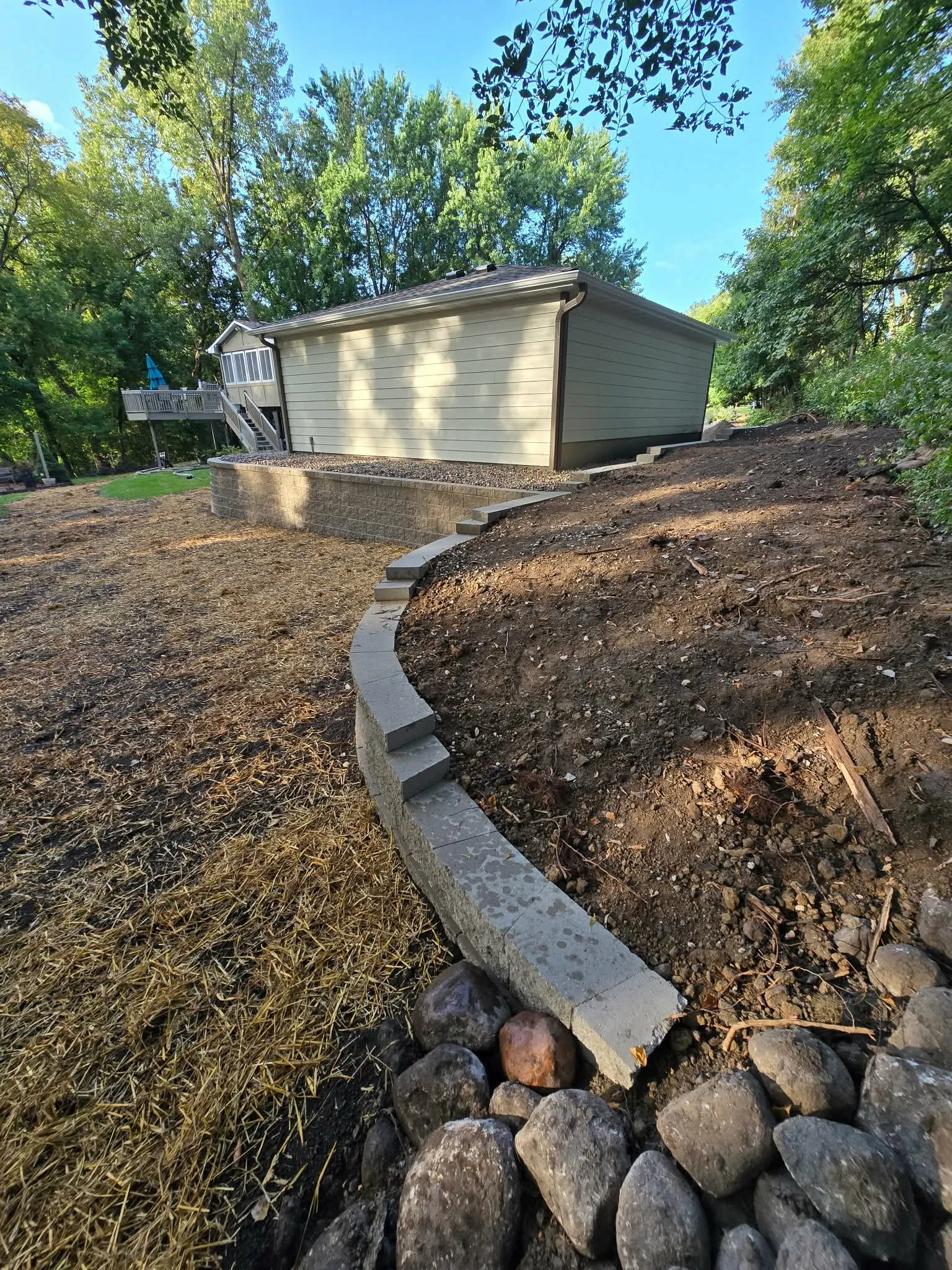 curved retaining wall installation for hillside erosion control Central Minnesota