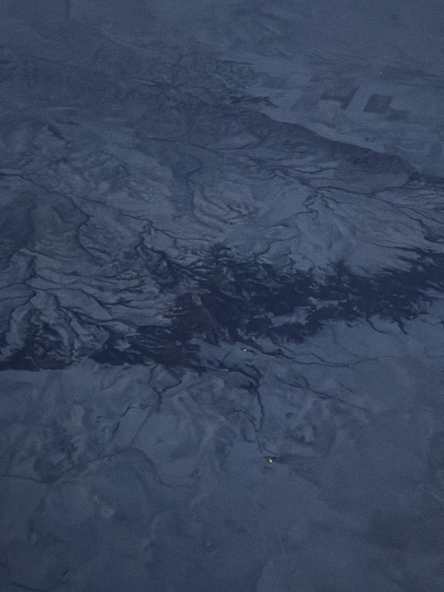 Close-up of crackled ice surface with dark blue hues