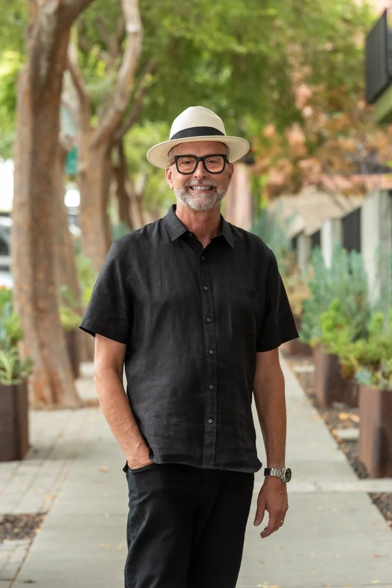 Real Estate Agent Scott R Kline in black shirt and Panama hat with trees in background.