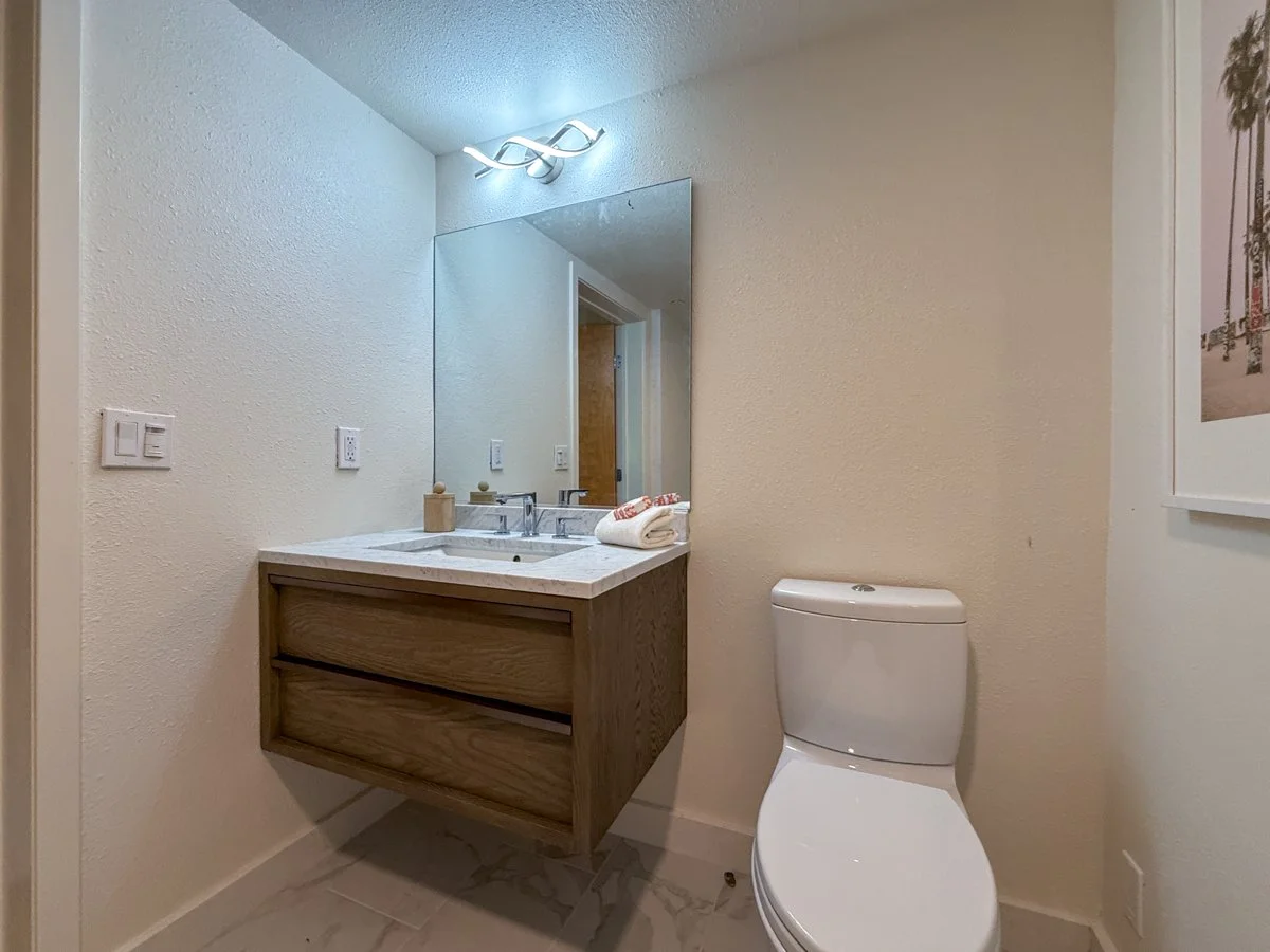 Downstairs full bath has RH floating vanity with quartz counter.