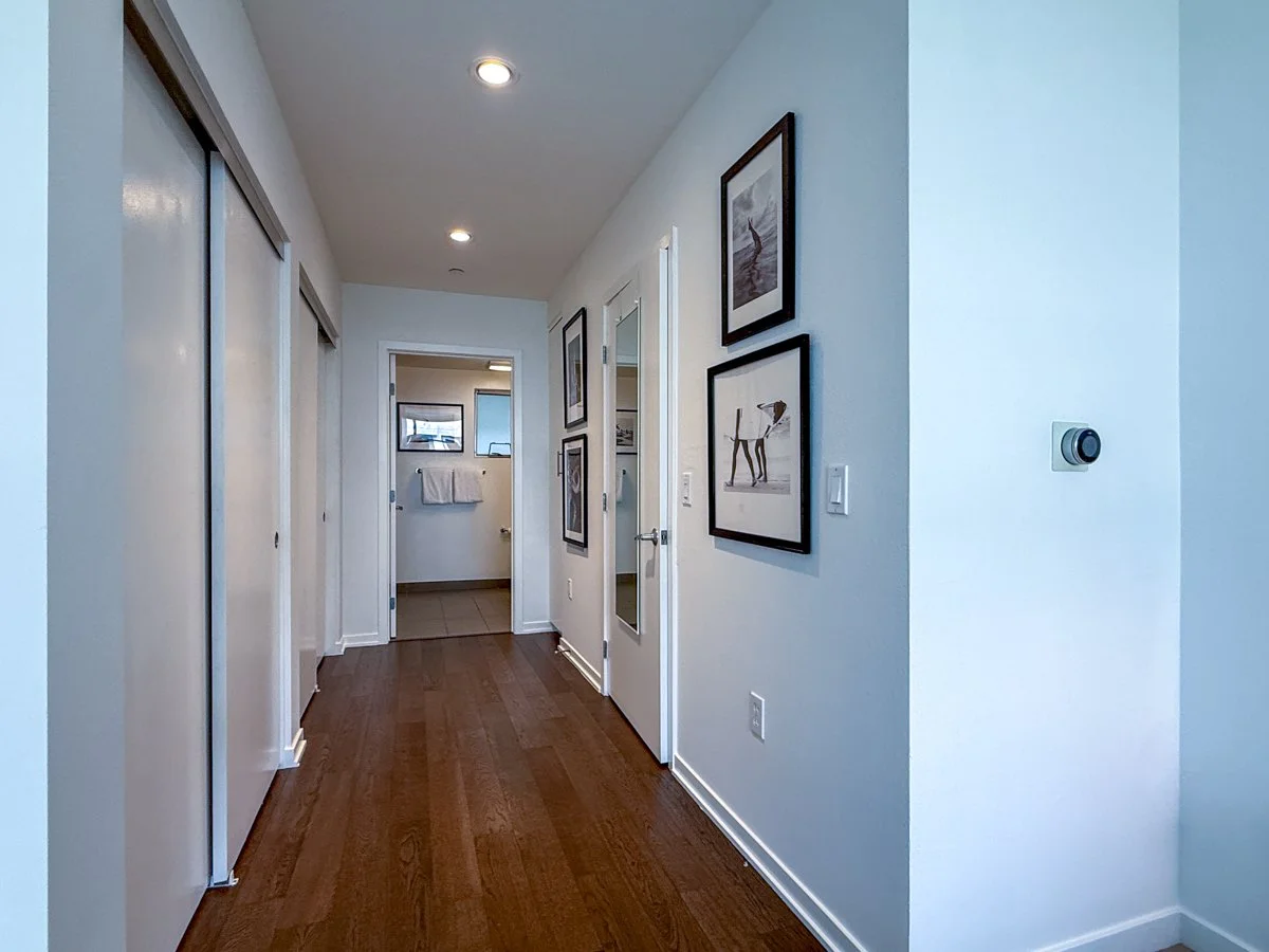 Hallway from bedroom to primary en suite bath and ample closet space