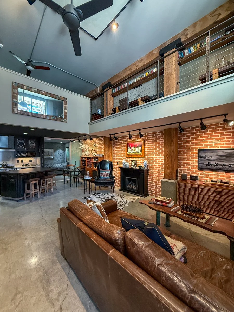 Downstairs great room from entry with concrete floors, remodeled kitchen and 15 foot high ceilings.