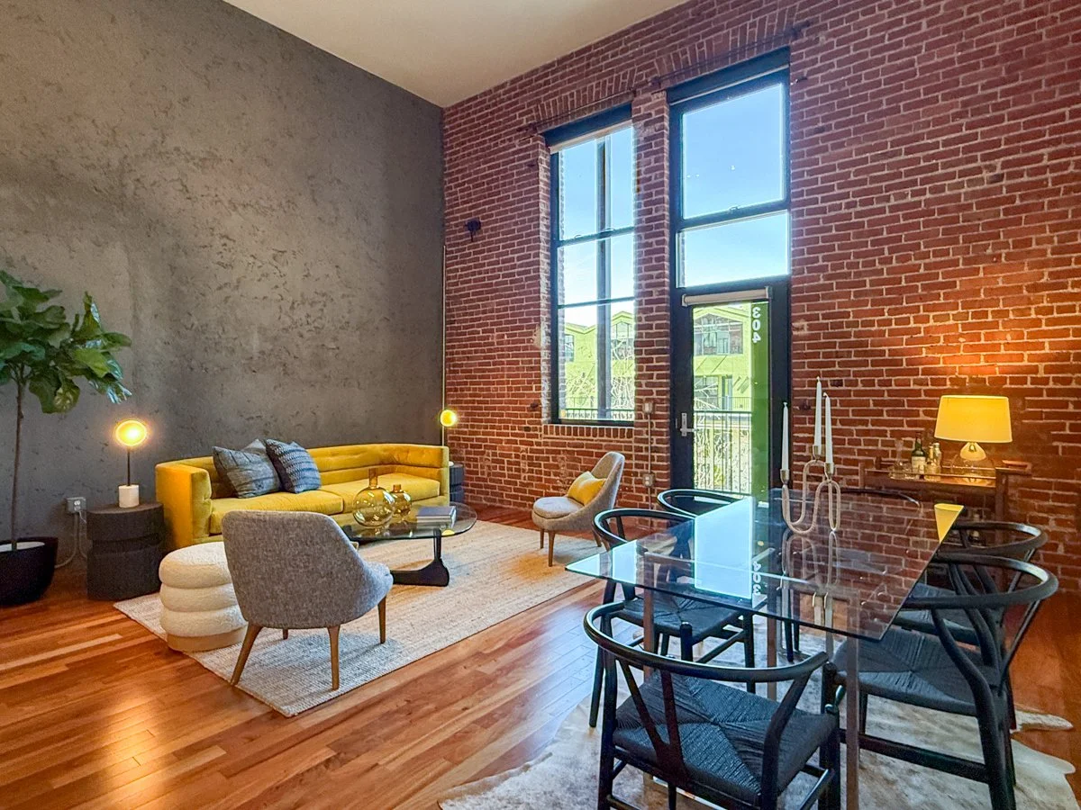Main living area with 15 foot ceilings, brick wall, concrete wall, wood floors, radiant heat.