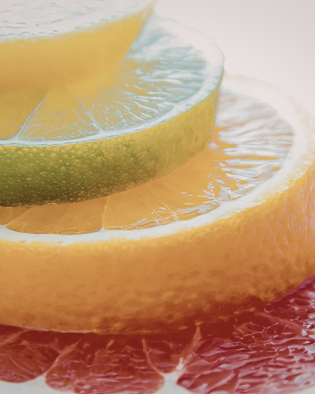 Close-up of layered citrus fruit slices, including lemon, orange, lime, and grapefruit.