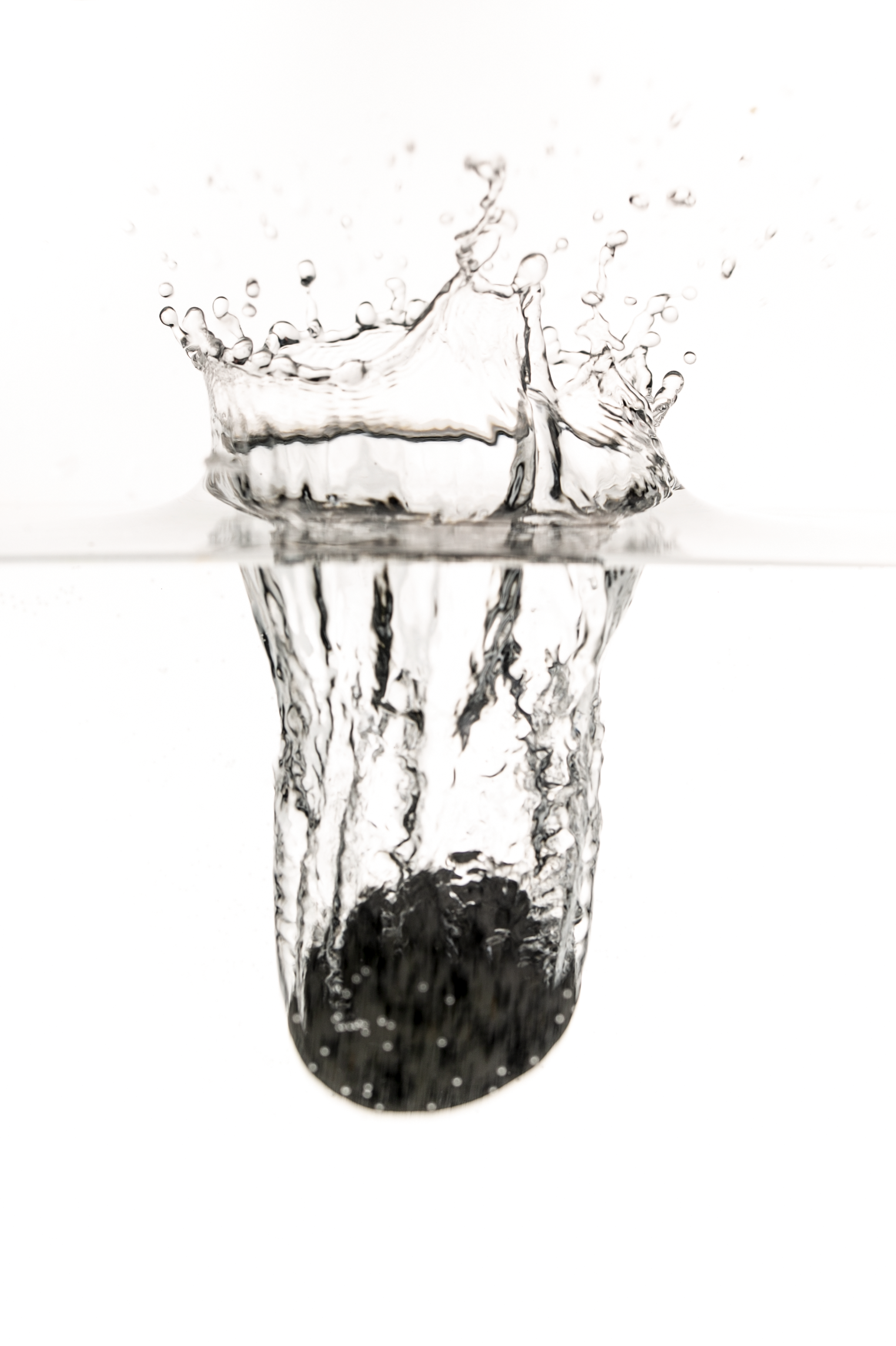 A splash of water with ripples and droplets, captured mid-air against a plain white background.